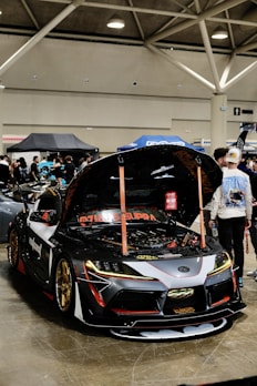 A group of people standing around a car in a garage