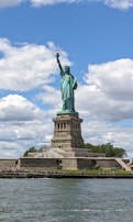 The statue of liberty is in the middle of the water
