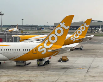 A yellow and white plane is parked at an airport