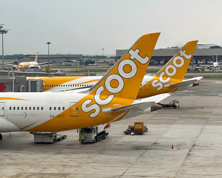A yellow and white plane is parked at an airport