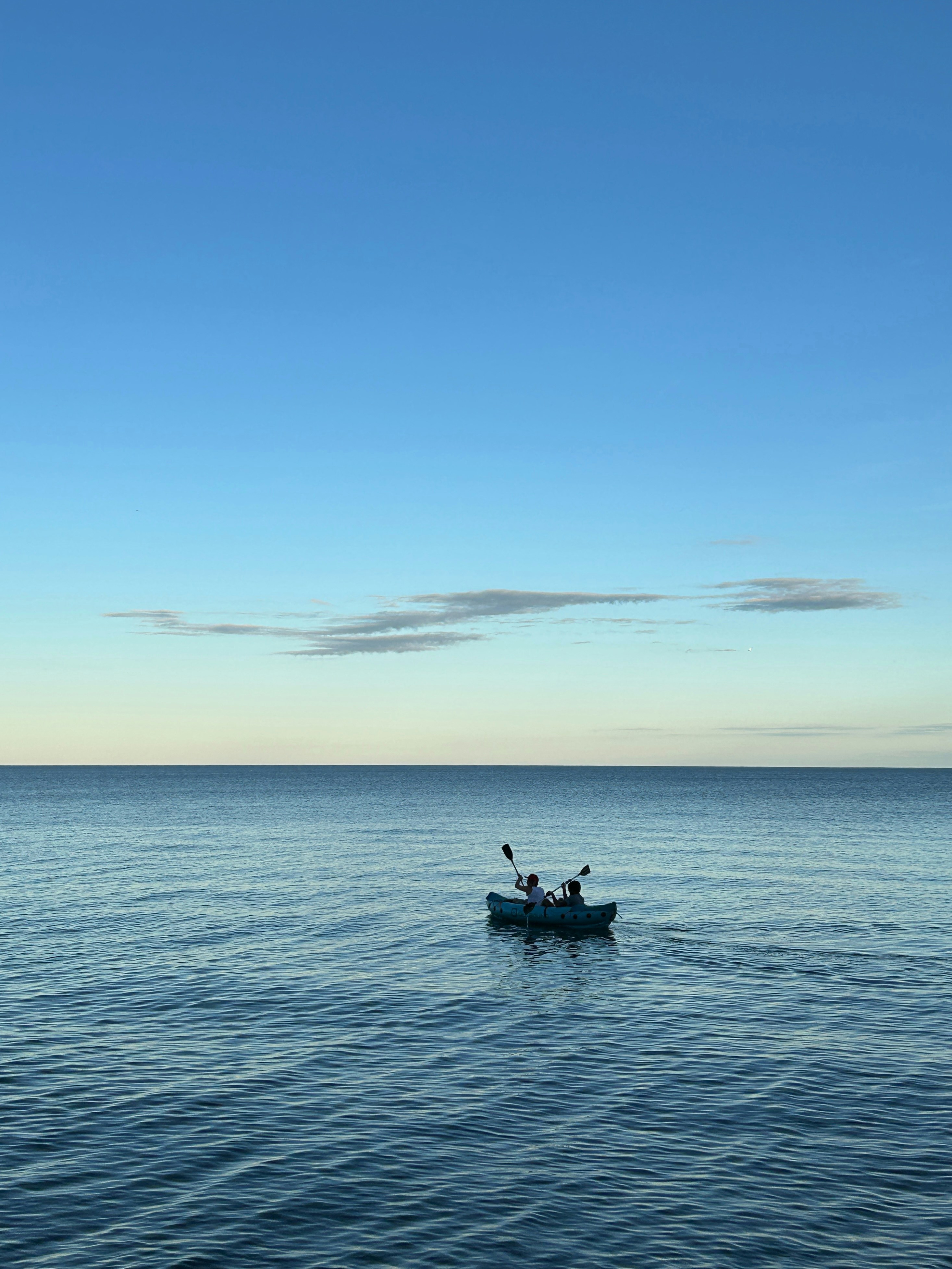 A small boat floating on top of a large body of water