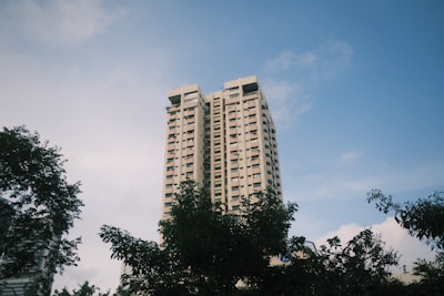 A tall white building with trees in front of it