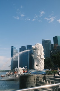 A statue of a mermaid in front of a city skyline