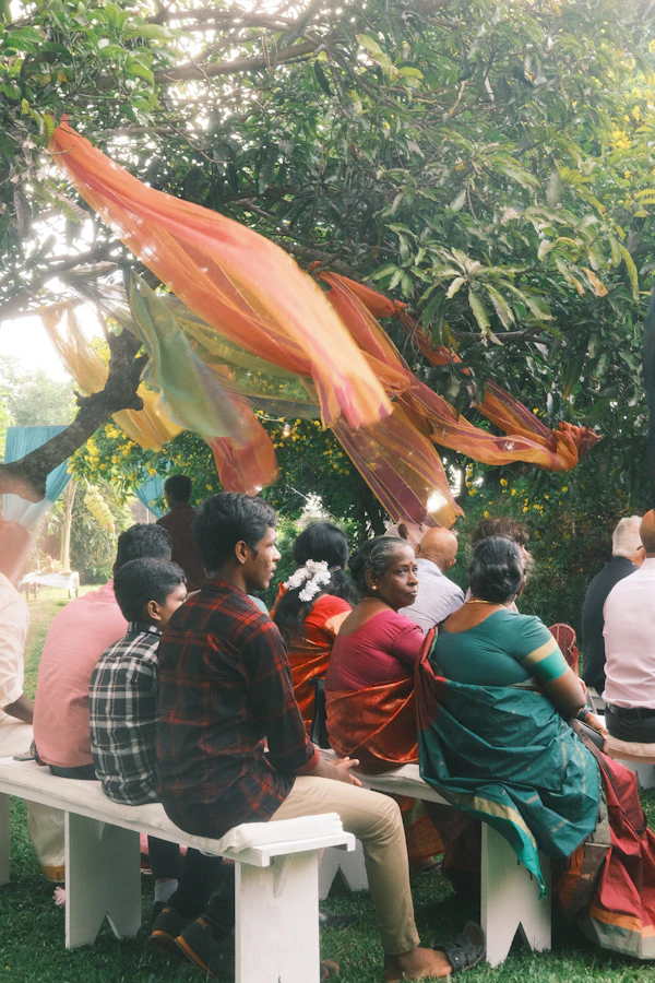 Wedding guests seated under colourful decorations
