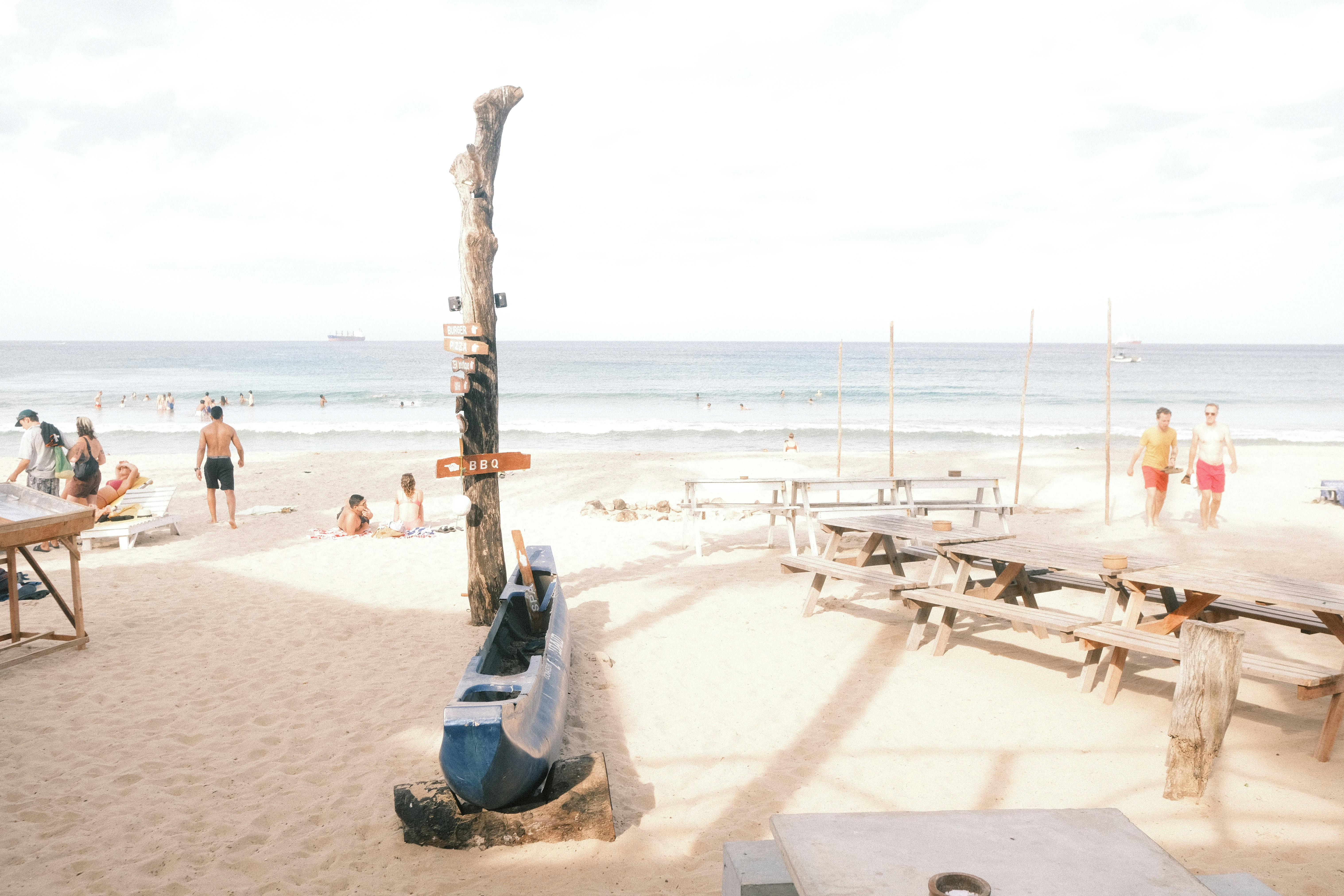 Un groupe de personnes debout au sommet d’une plage de sable