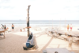 A group of people standing on top of a sandy beach