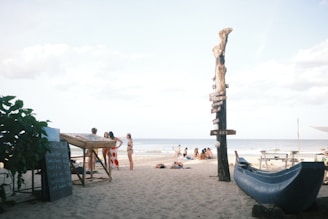 A beach with a blue slide and people on it