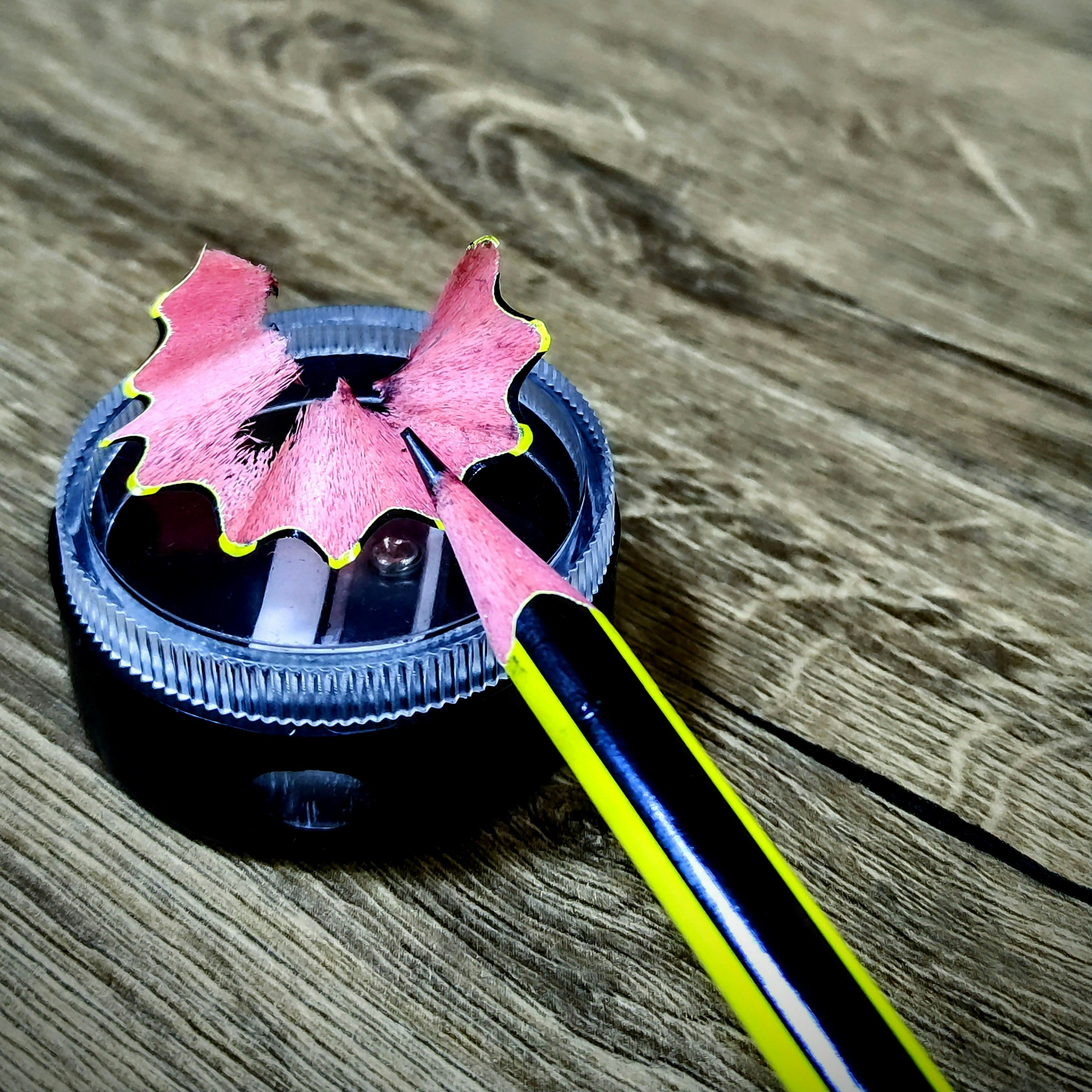 Un objeto rosa y negro sentado encima de una mesa de madera