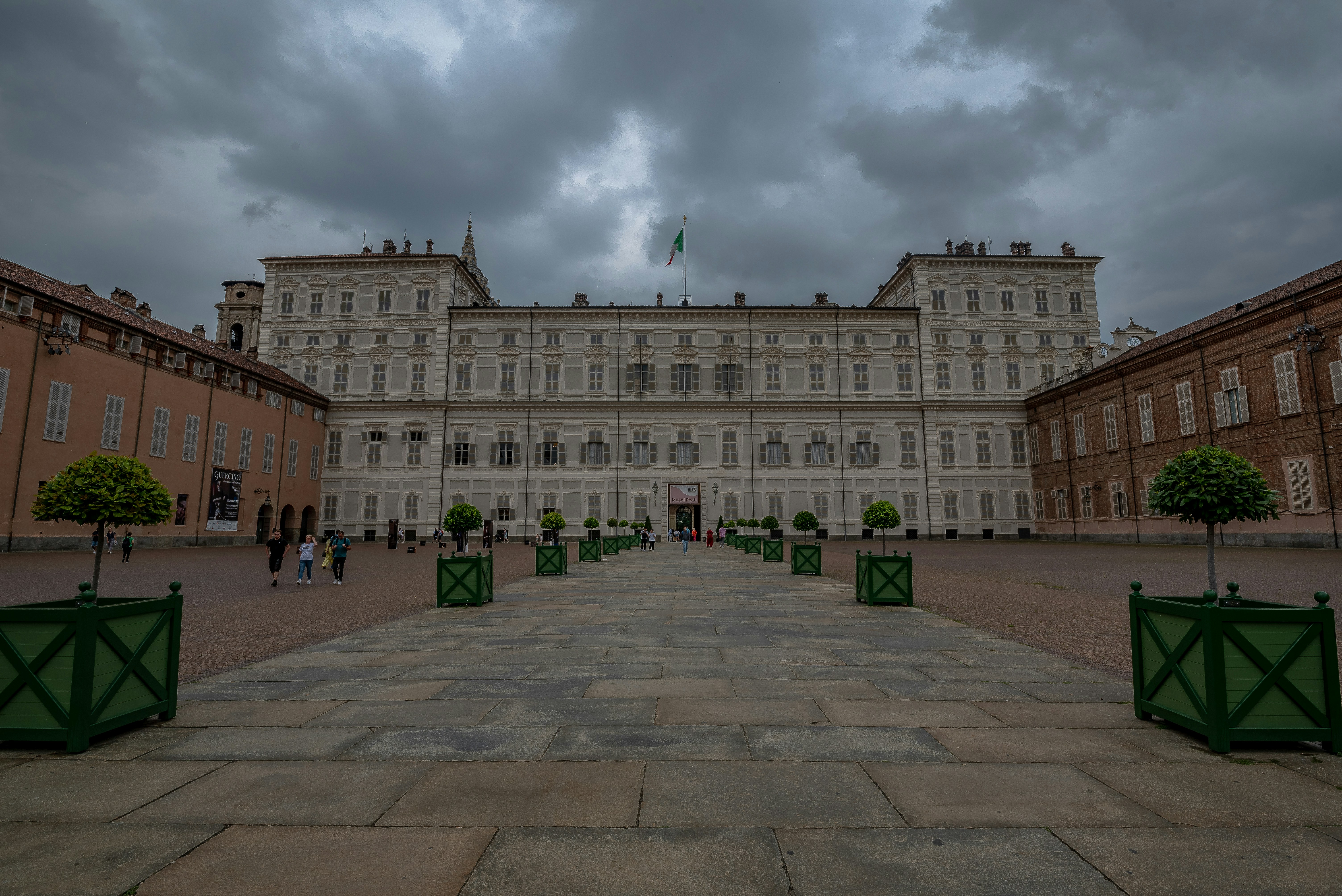 A large white building with a green gate in front of it