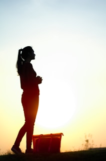A woman standing on top of a grass covered field