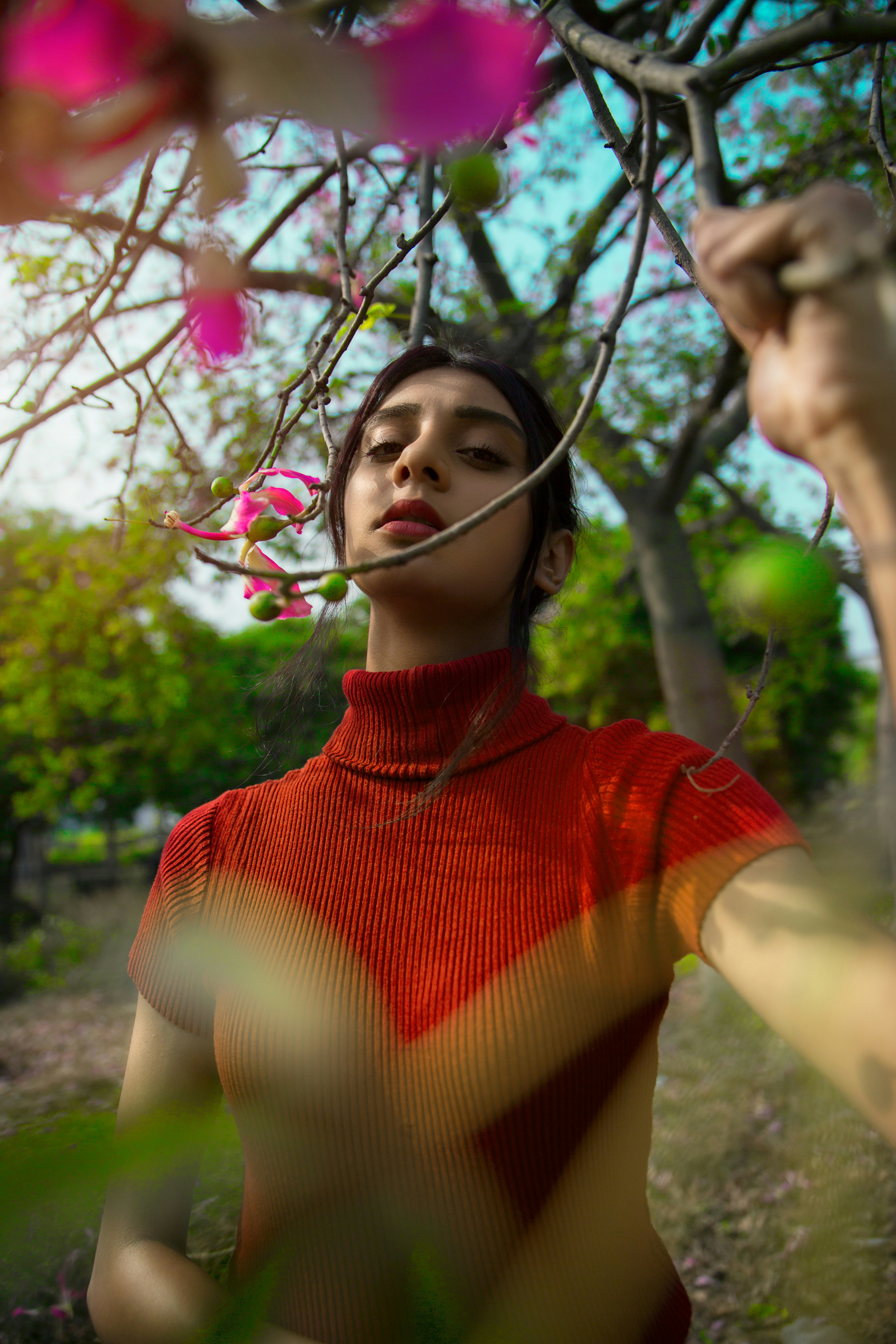 A man standing under a tree with pink flowers