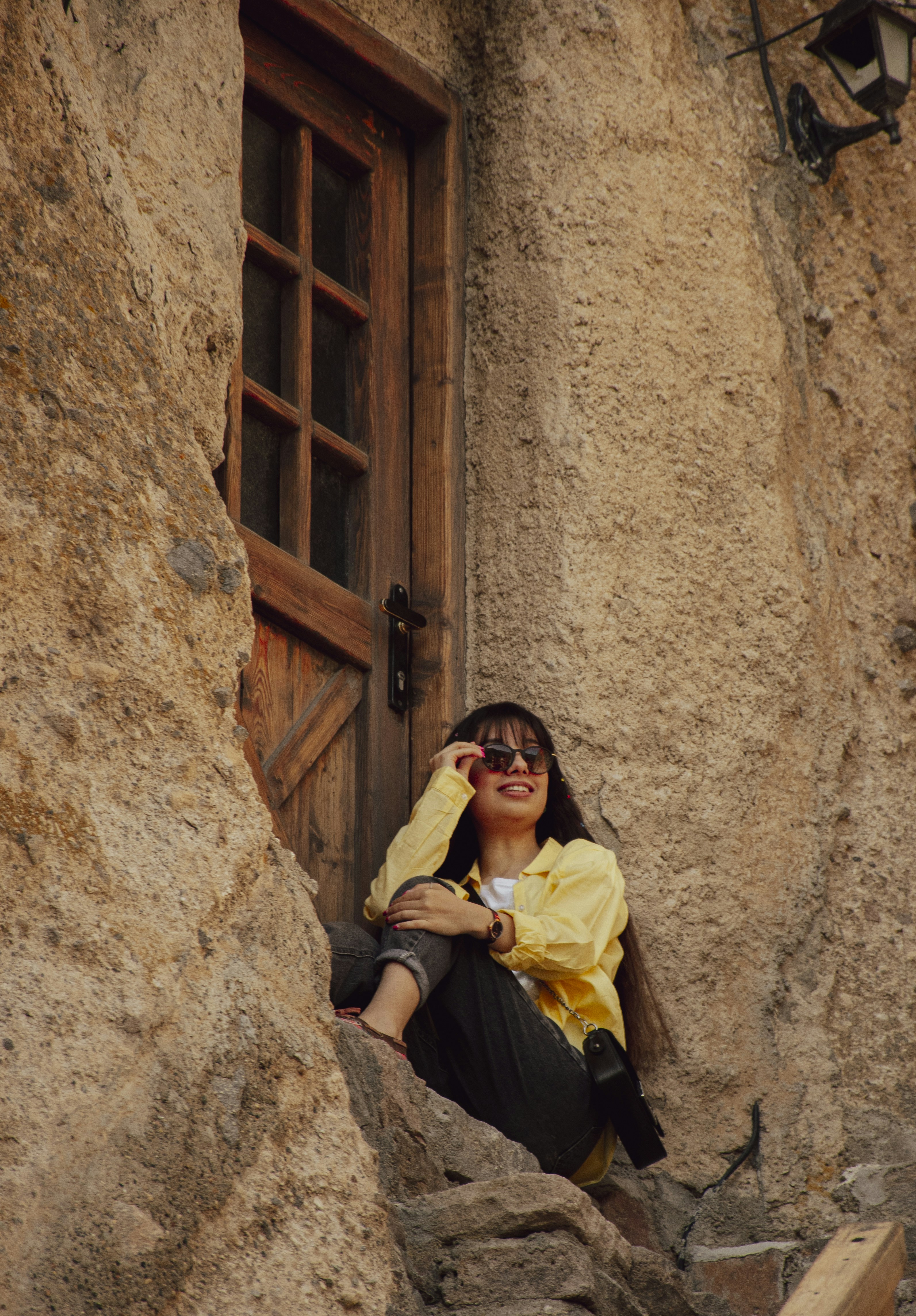 A woman sitting on a ledge in front of a door