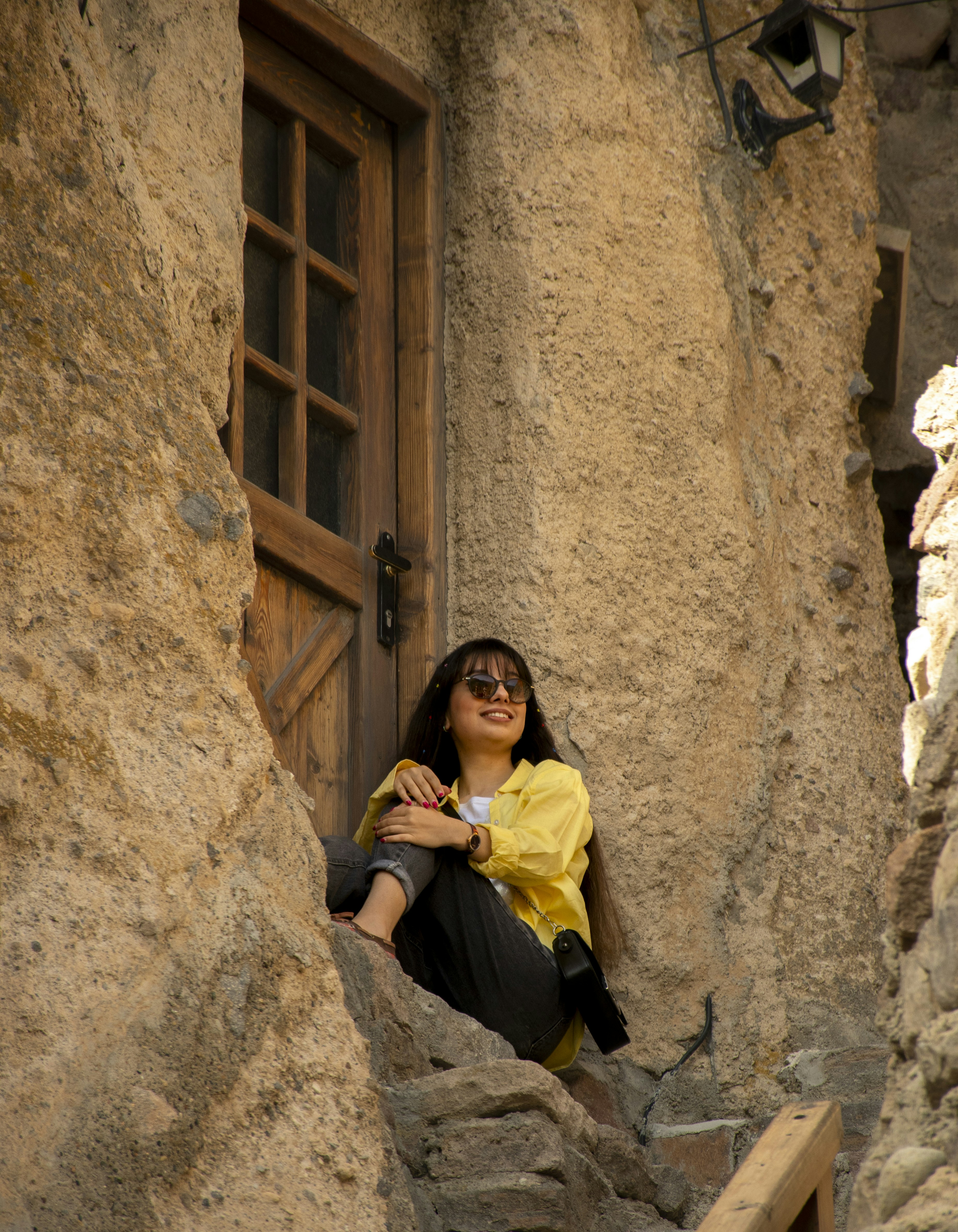 A woman sitting on a ledge in a stone building