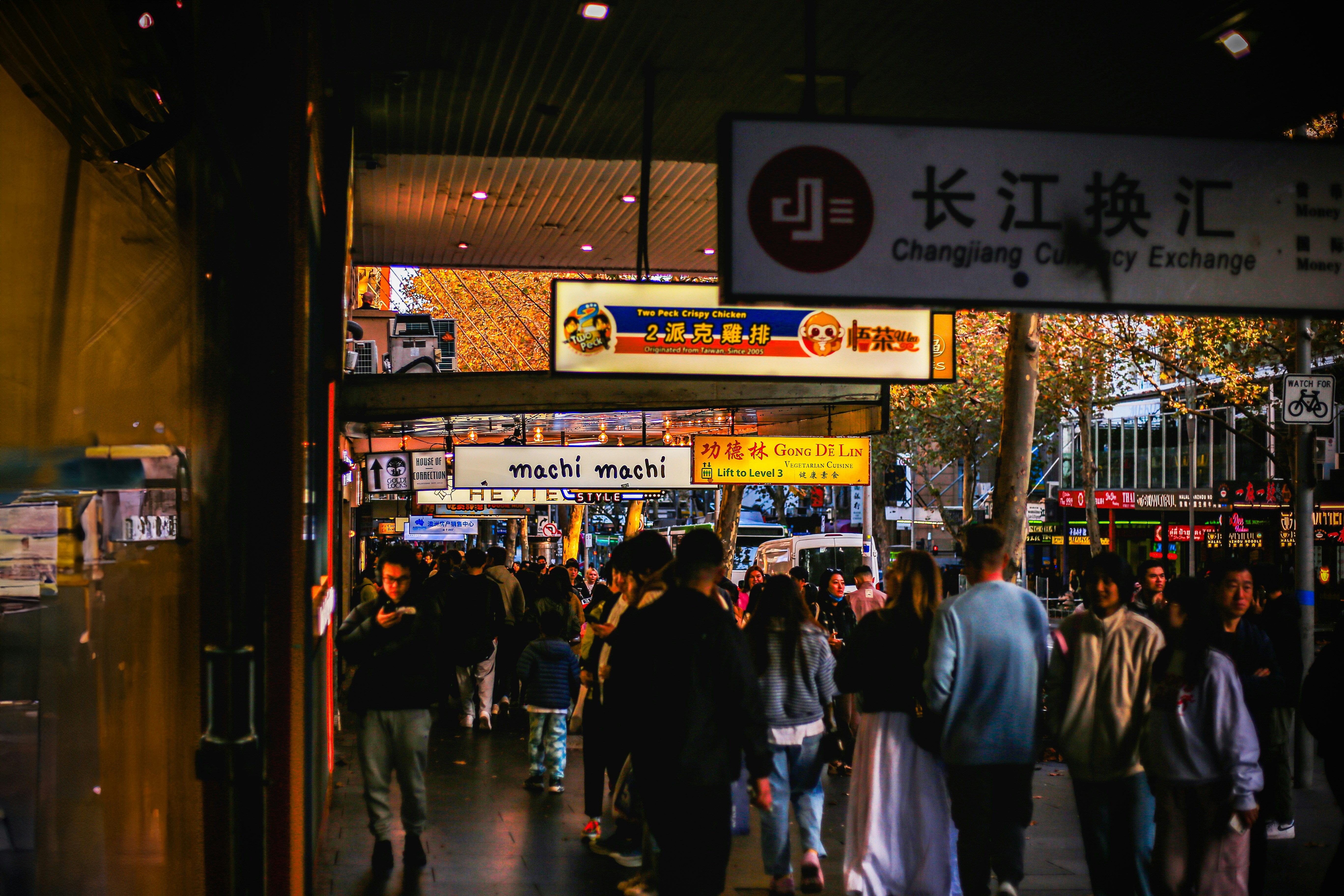 A crowd of people walking down a street at night