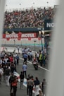 A crowd of people walking around a race track