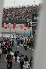 A crowd of people walking around a race track