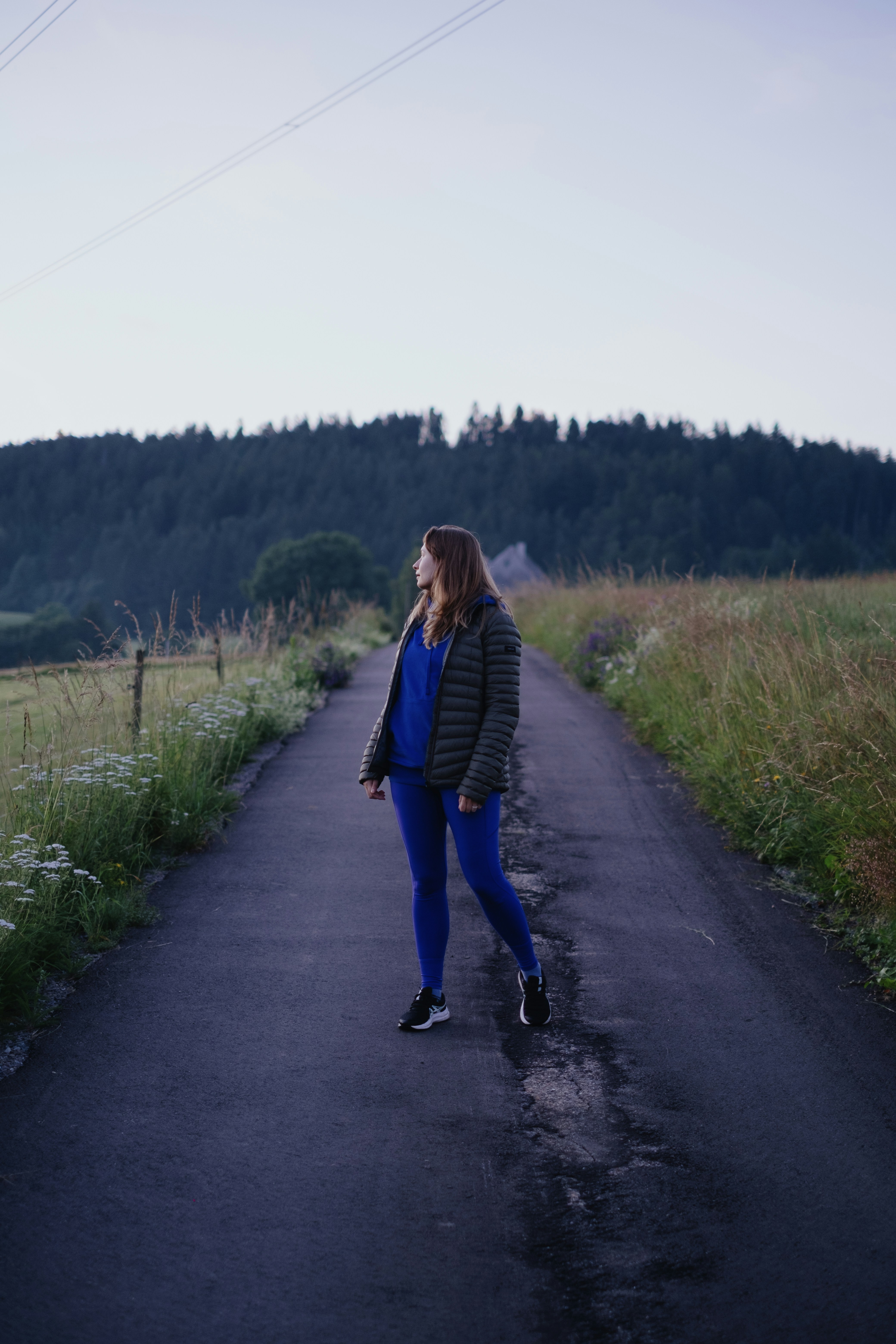 Eine Frau, die auf einer Straße mitten auf einem Feld steht