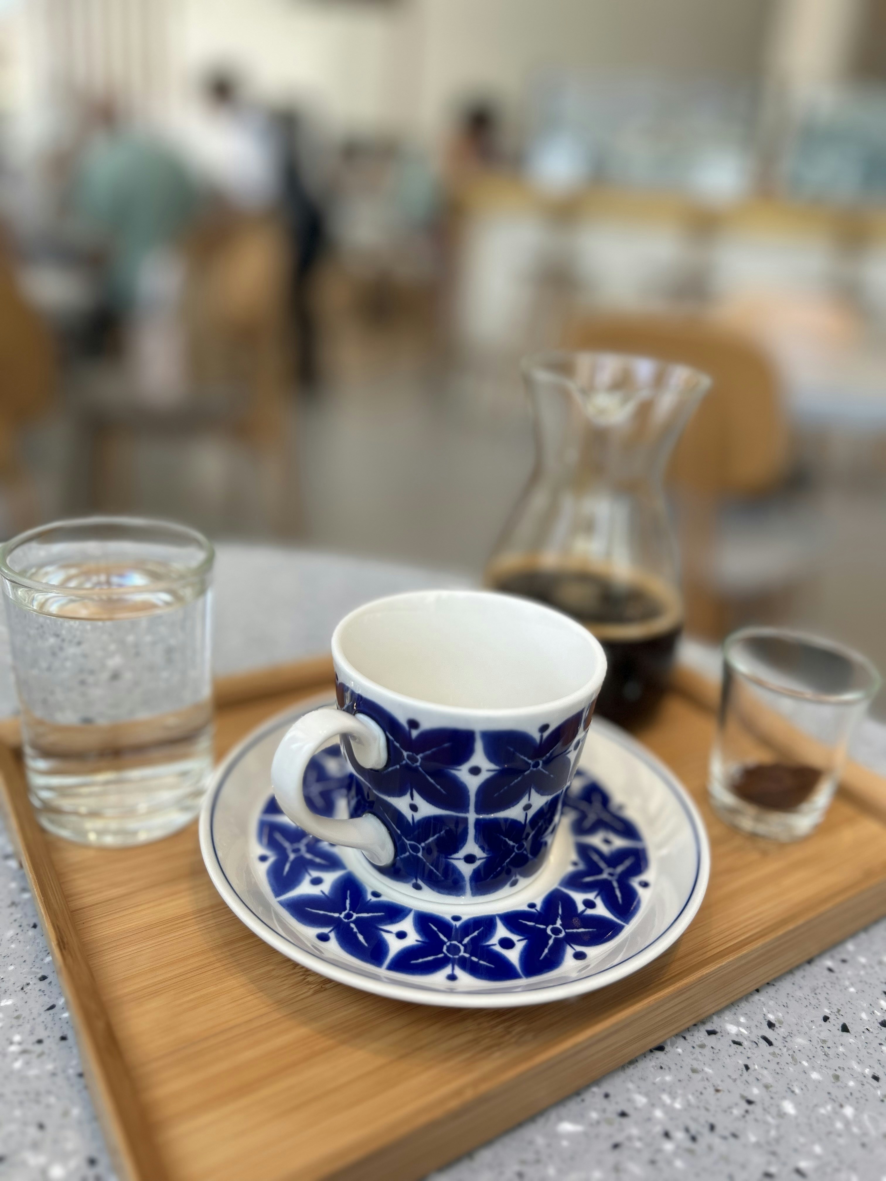 A blue and white cup and saucer on a wooden tray