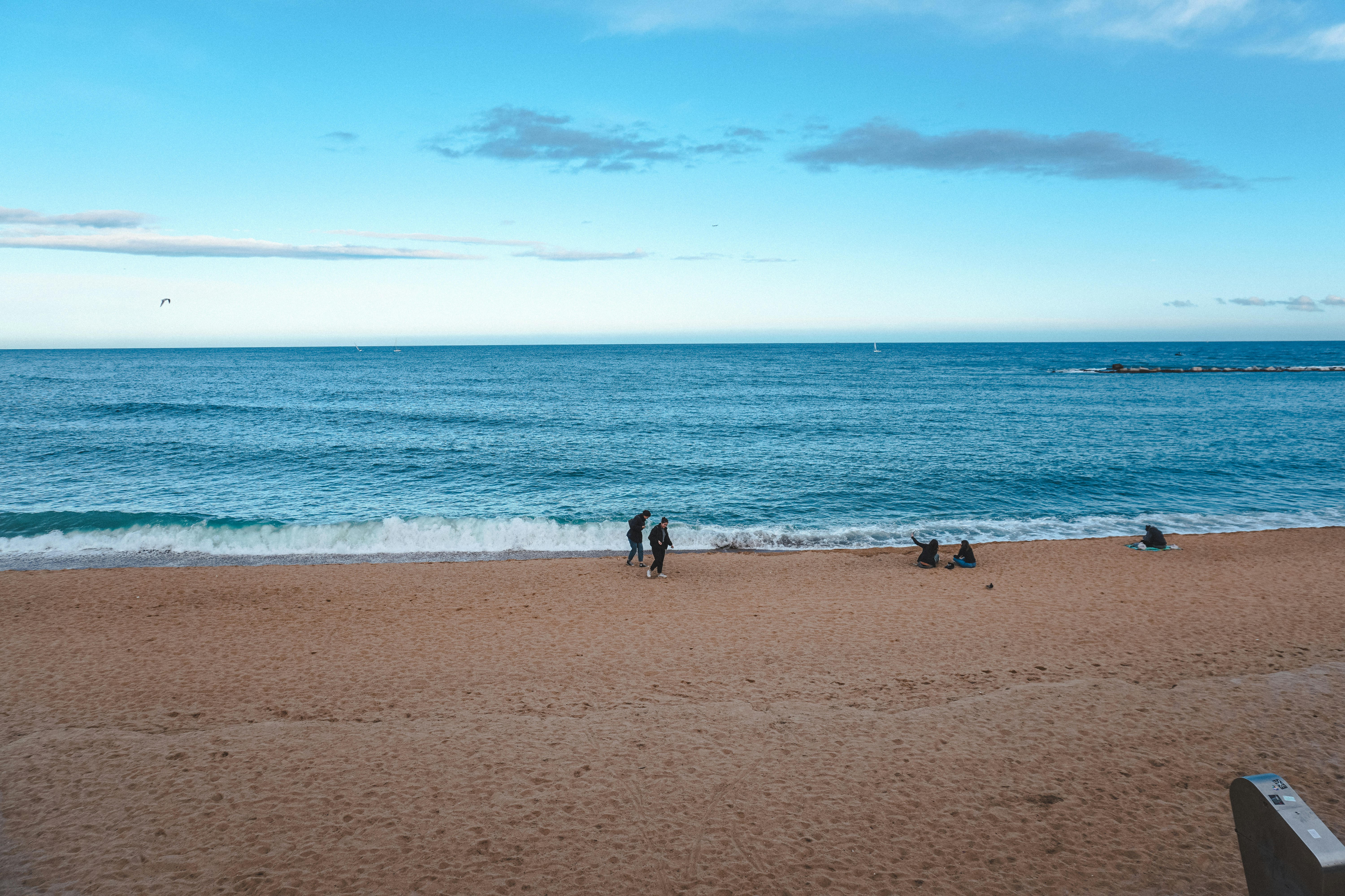 A group of people standing on top of a sandy beach