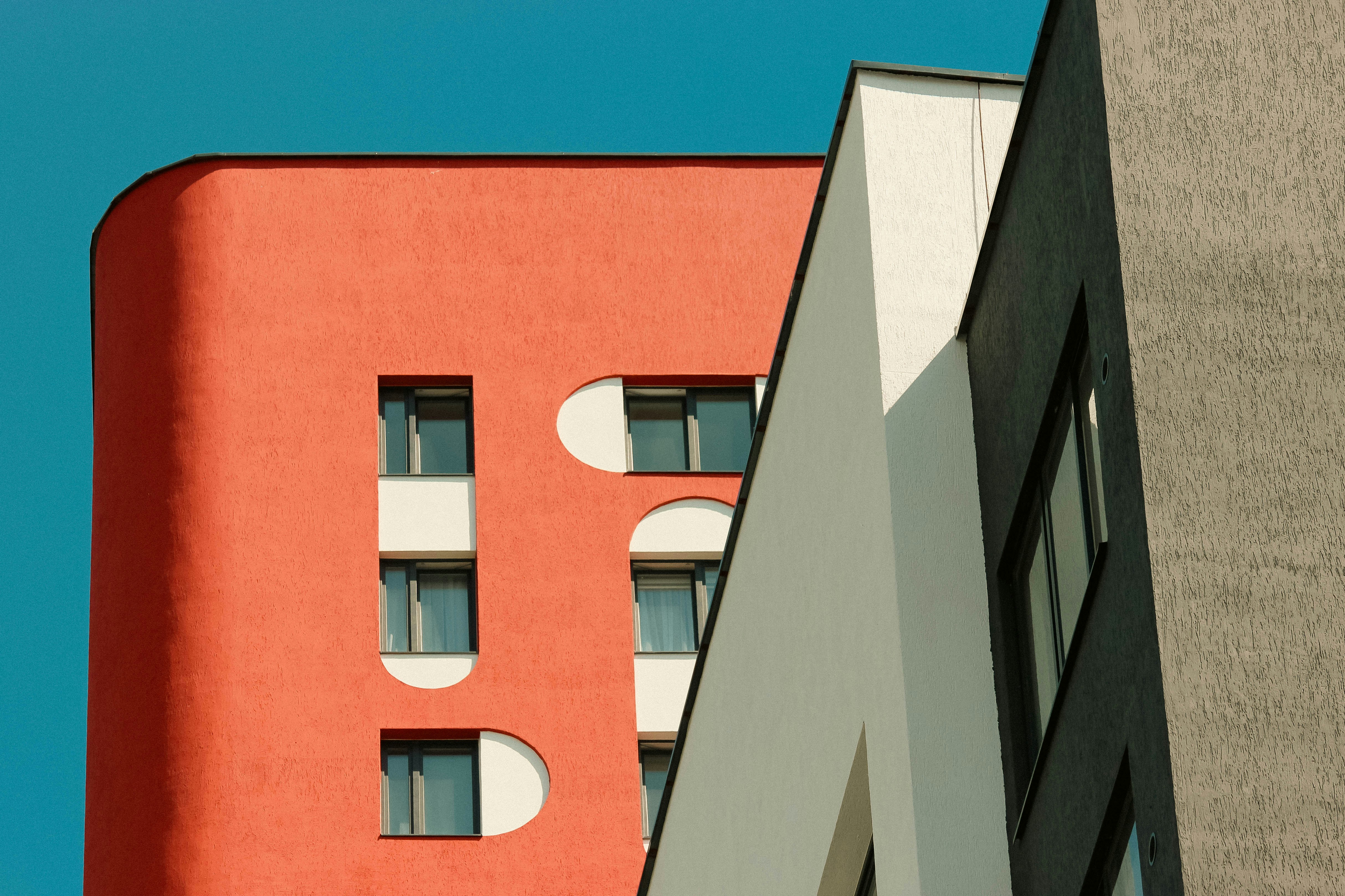 A tall red building next to a tall gray building