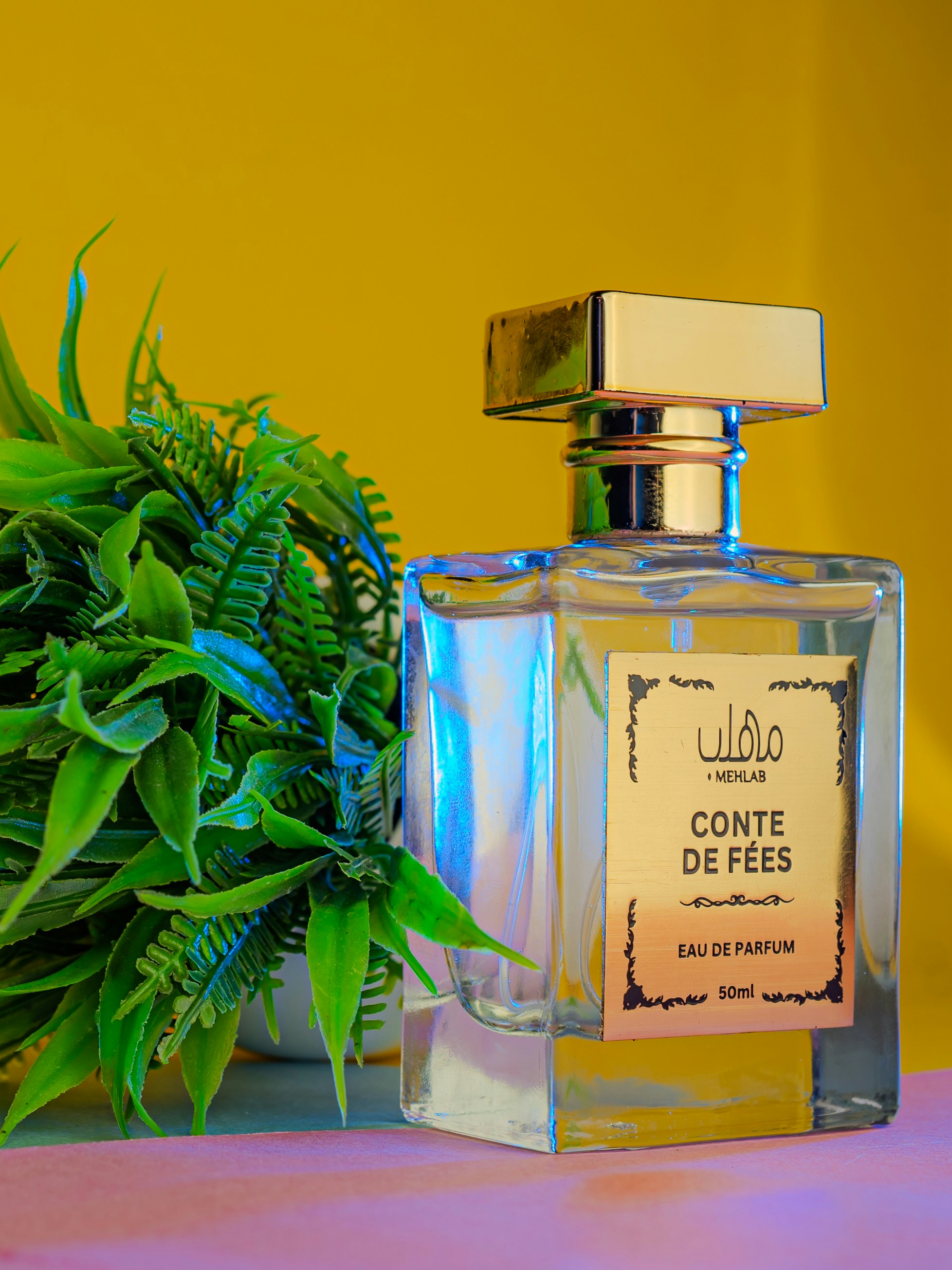 A bottle of perfume sitting next to a potted plant