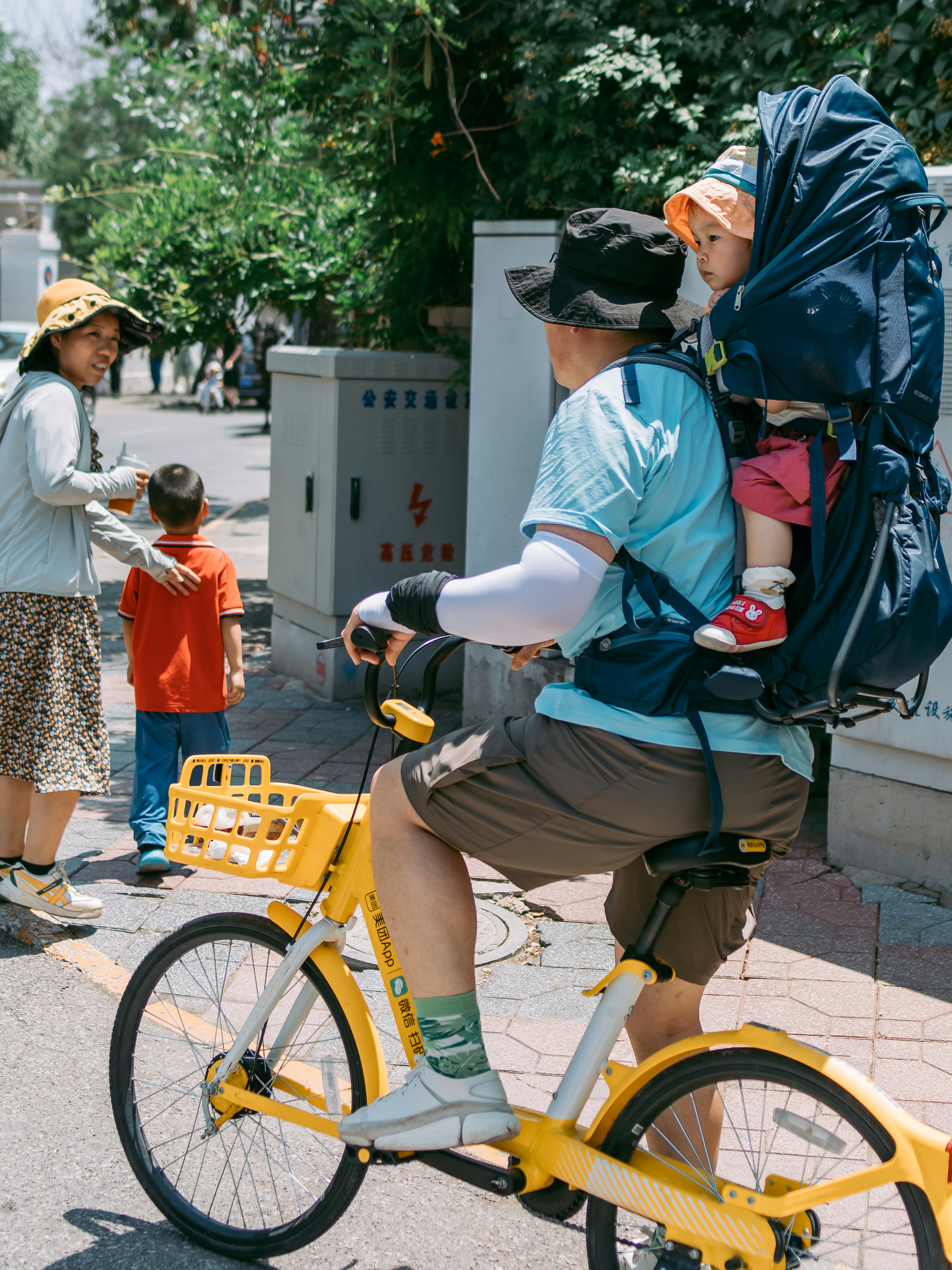 A man riding a bike with a child on the back