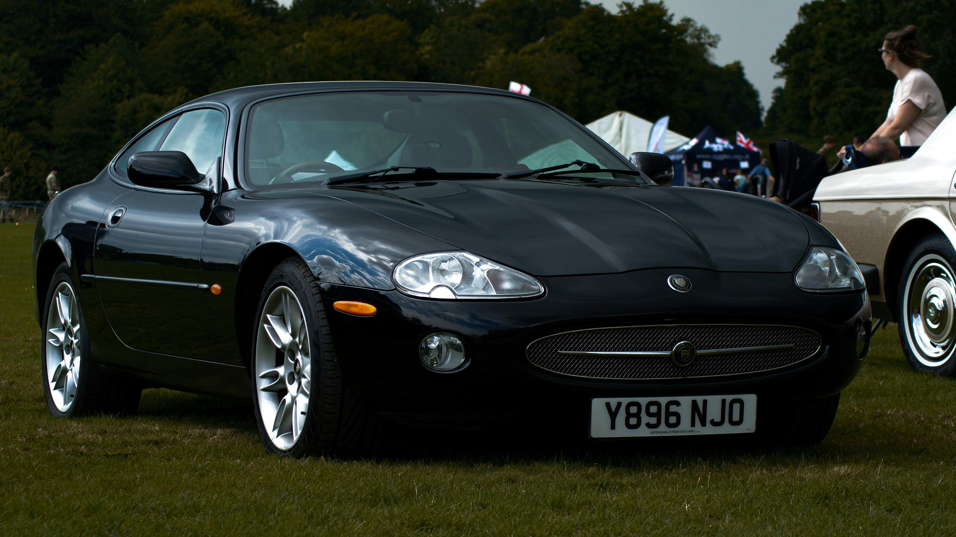 A couple of cars parked next to each other on a field