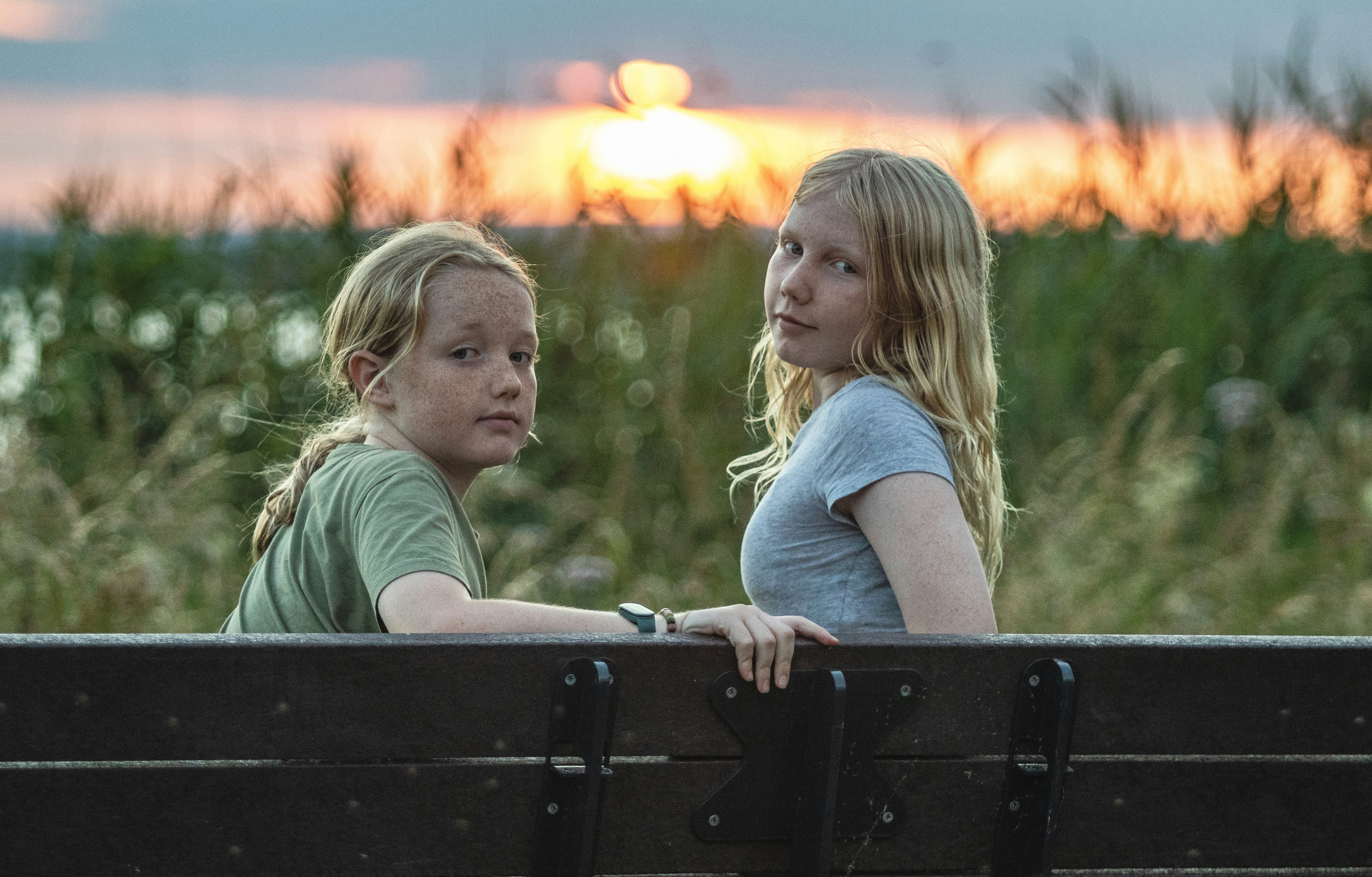 Two young girls sitting on a park bench (Photo by Lisa Marie Theck on Unsplash)
