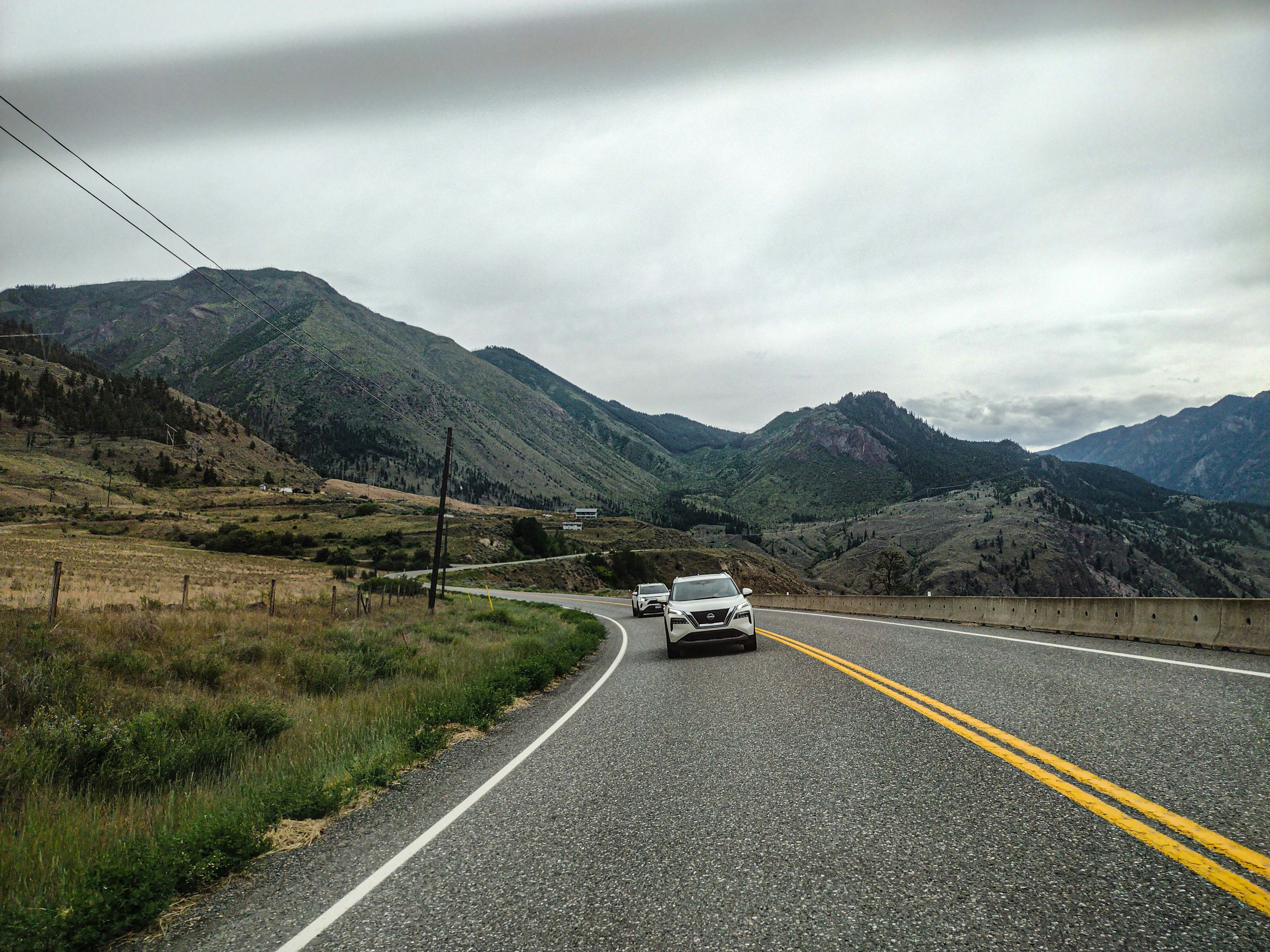 A car driving down a road with mountains in the background