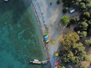 An aerial view of a beach with boats in the water