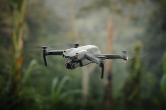 A white and black remote controlled flying over a forest