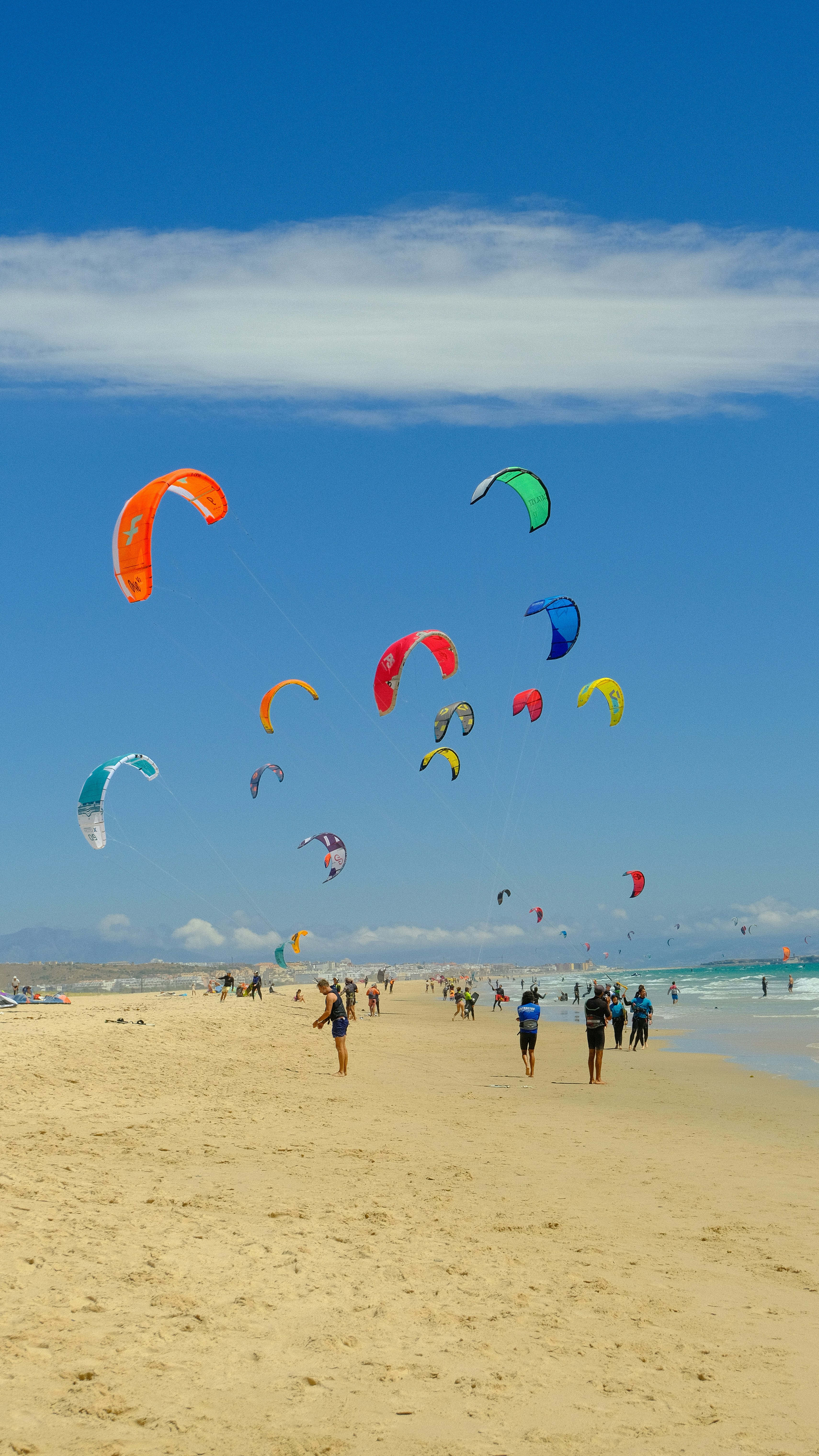 A group of people on a beach flying kites