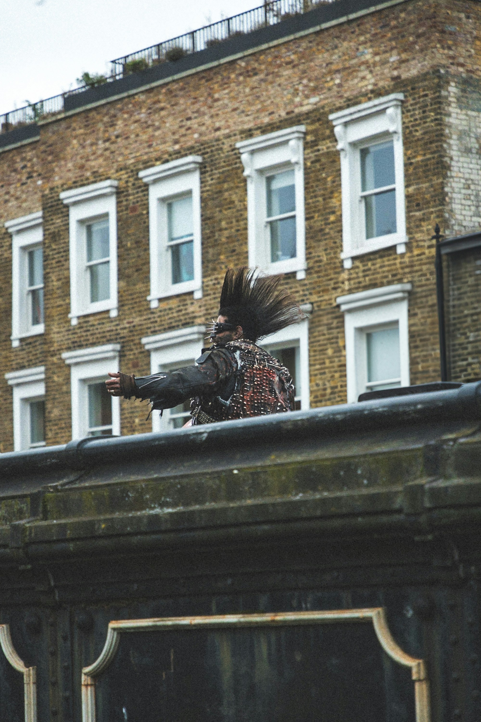 A man with a long hair standing on a roof
