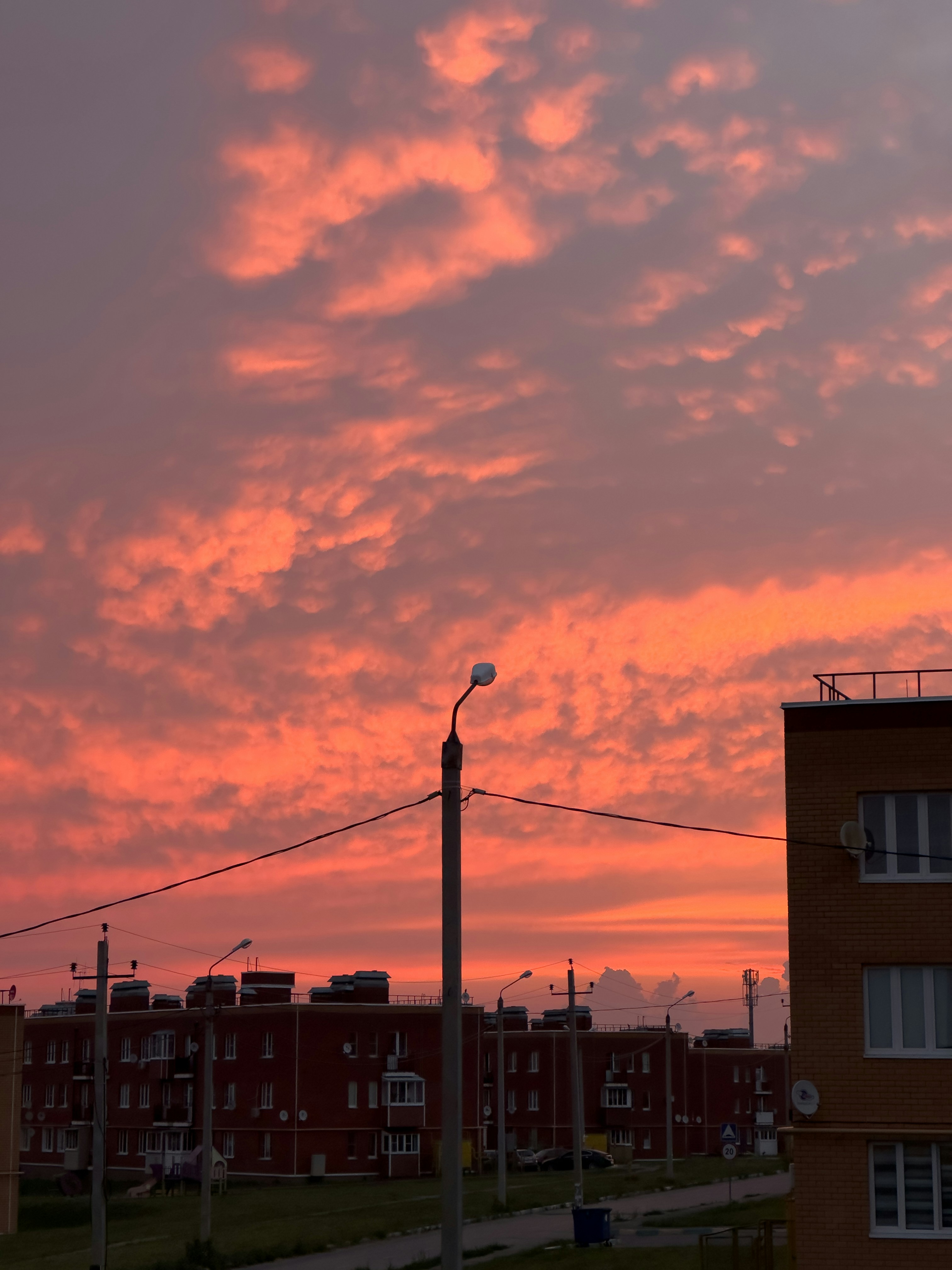 Um céu vermelho com nuvens e edifícios ao fundo