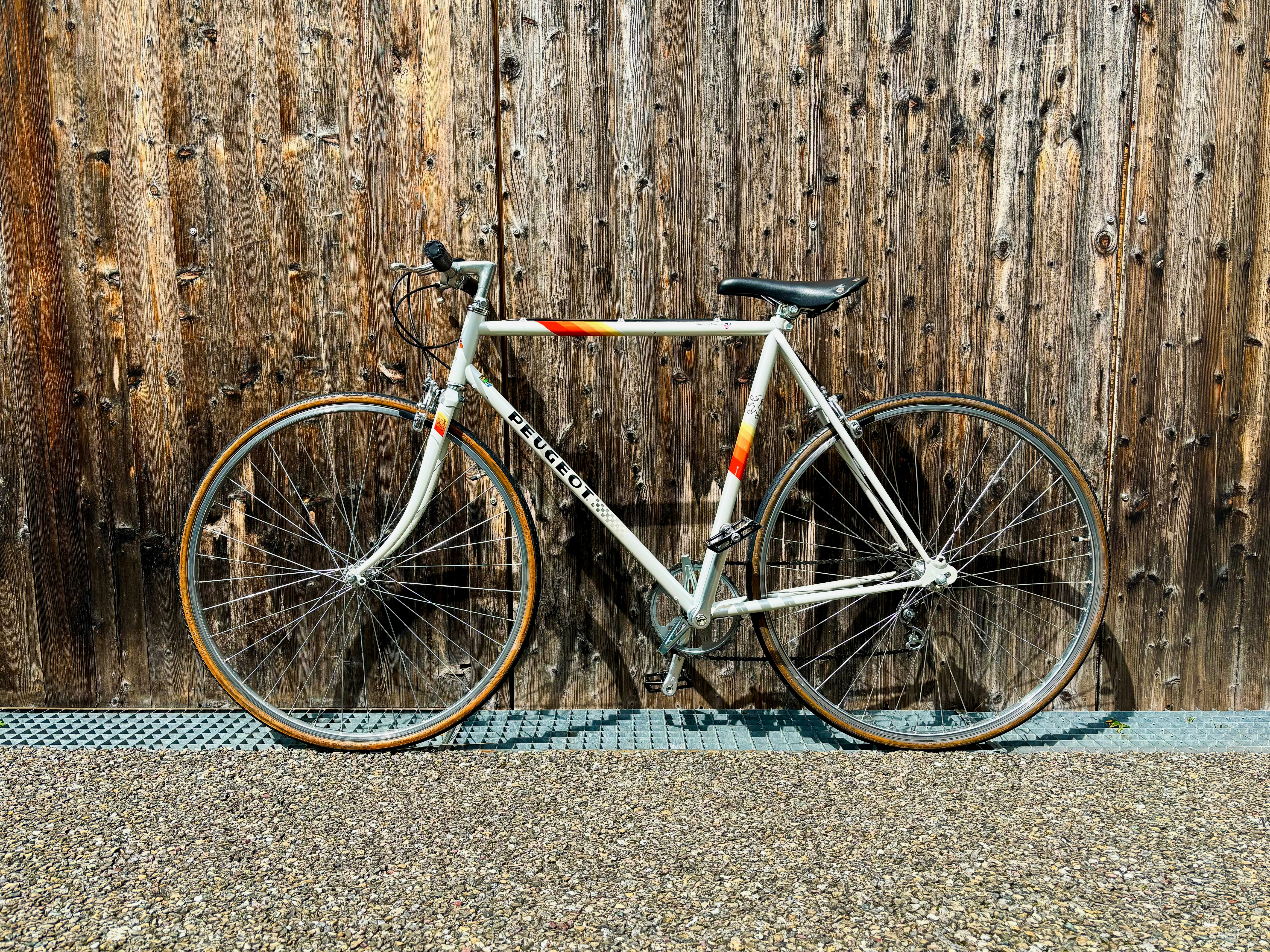 A bicycle parked next to a wooden fence