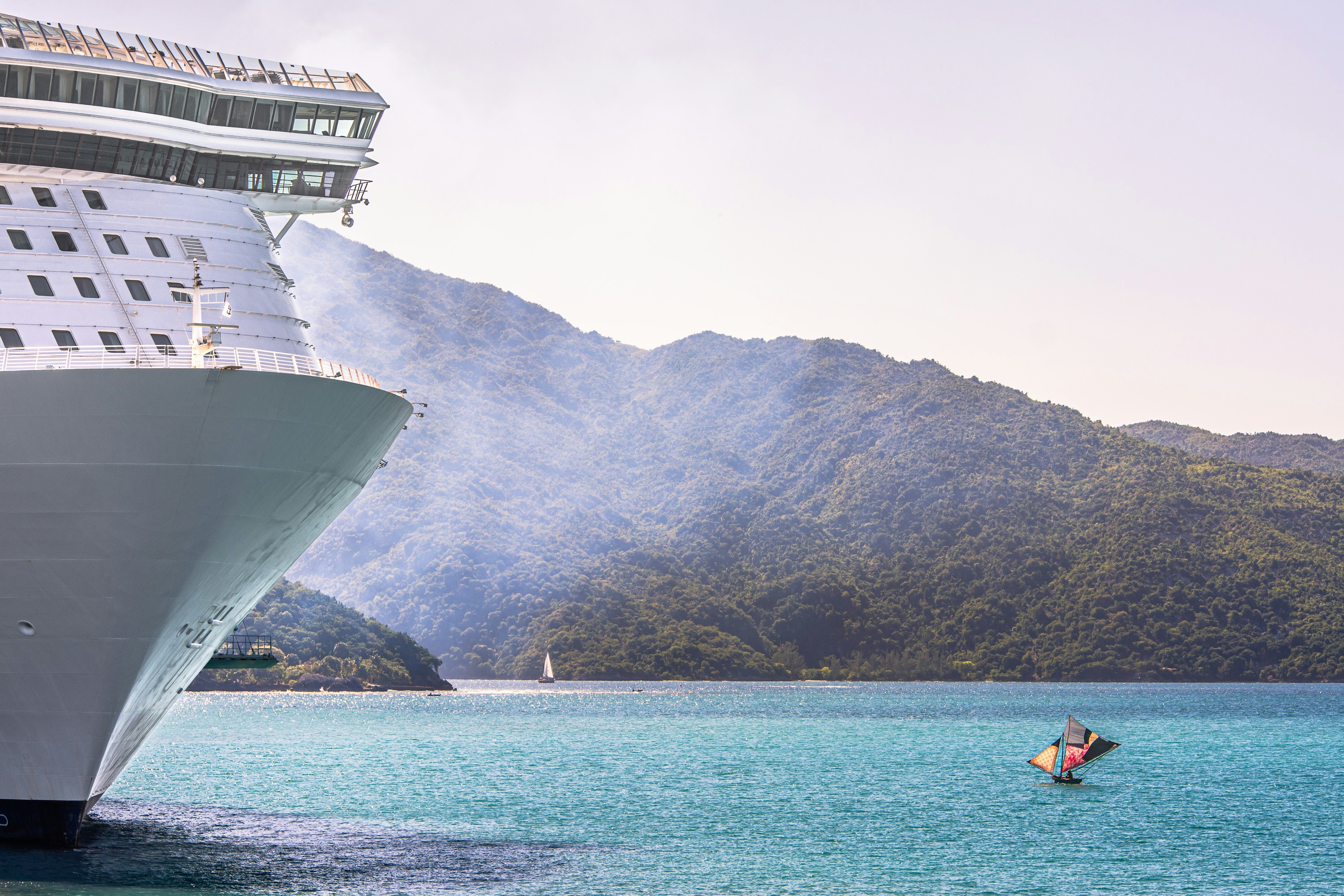 A cruise ship in the water with mountains in the background