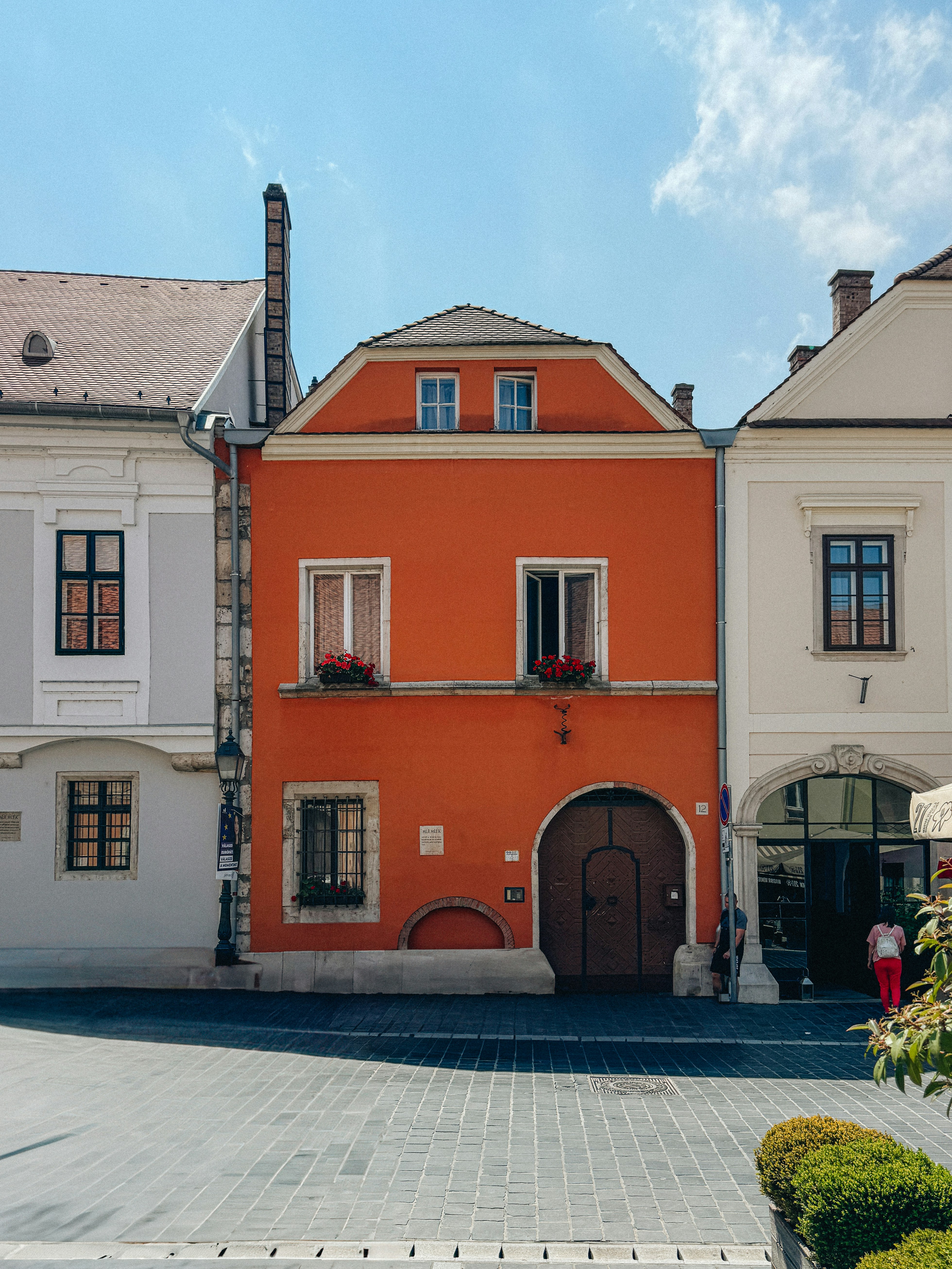 An orange building with a brown door and windows