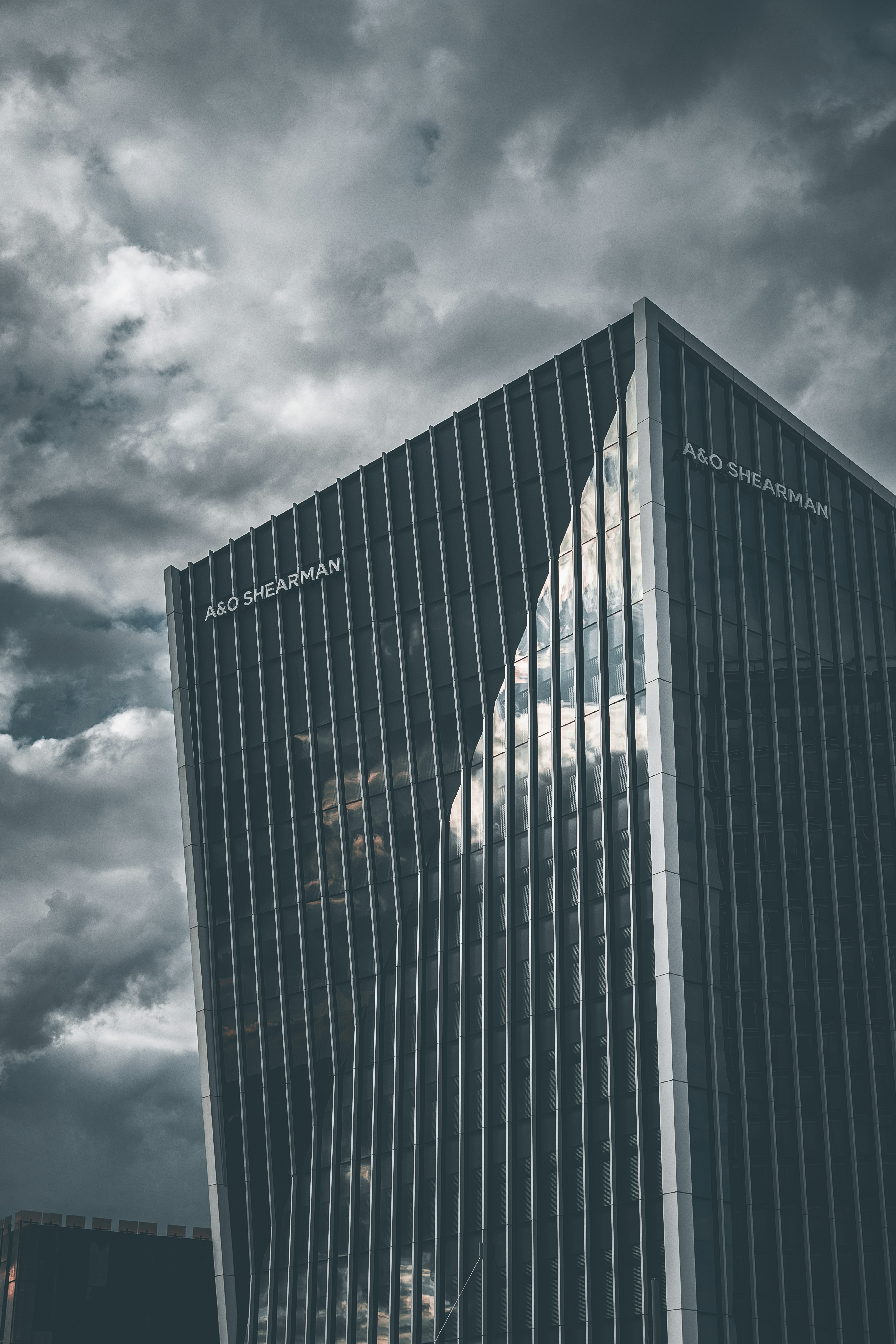 A tall building sitting under a cloudy sky photo – Free Building Image ...