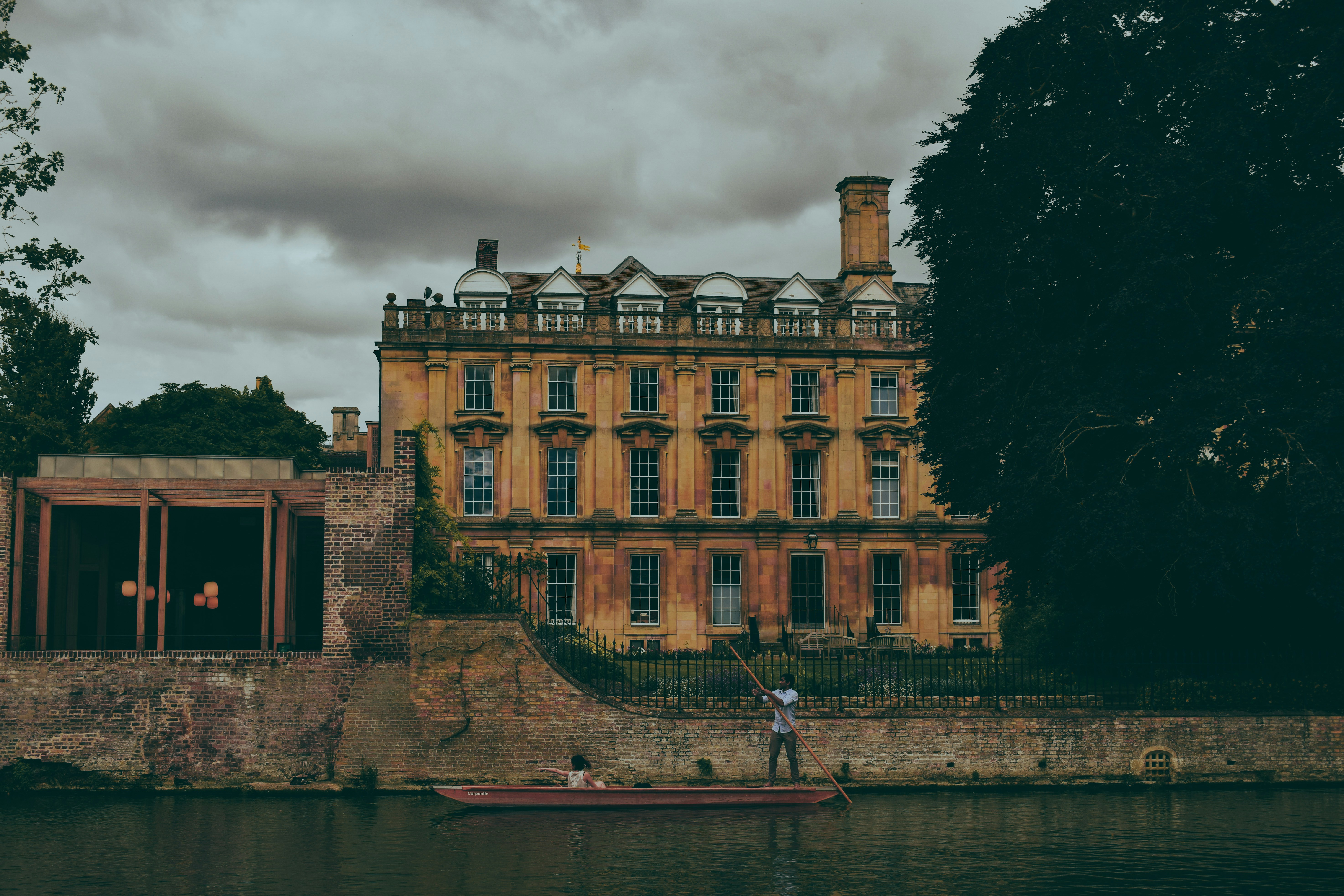 A man standing on a boat in front of a large building
