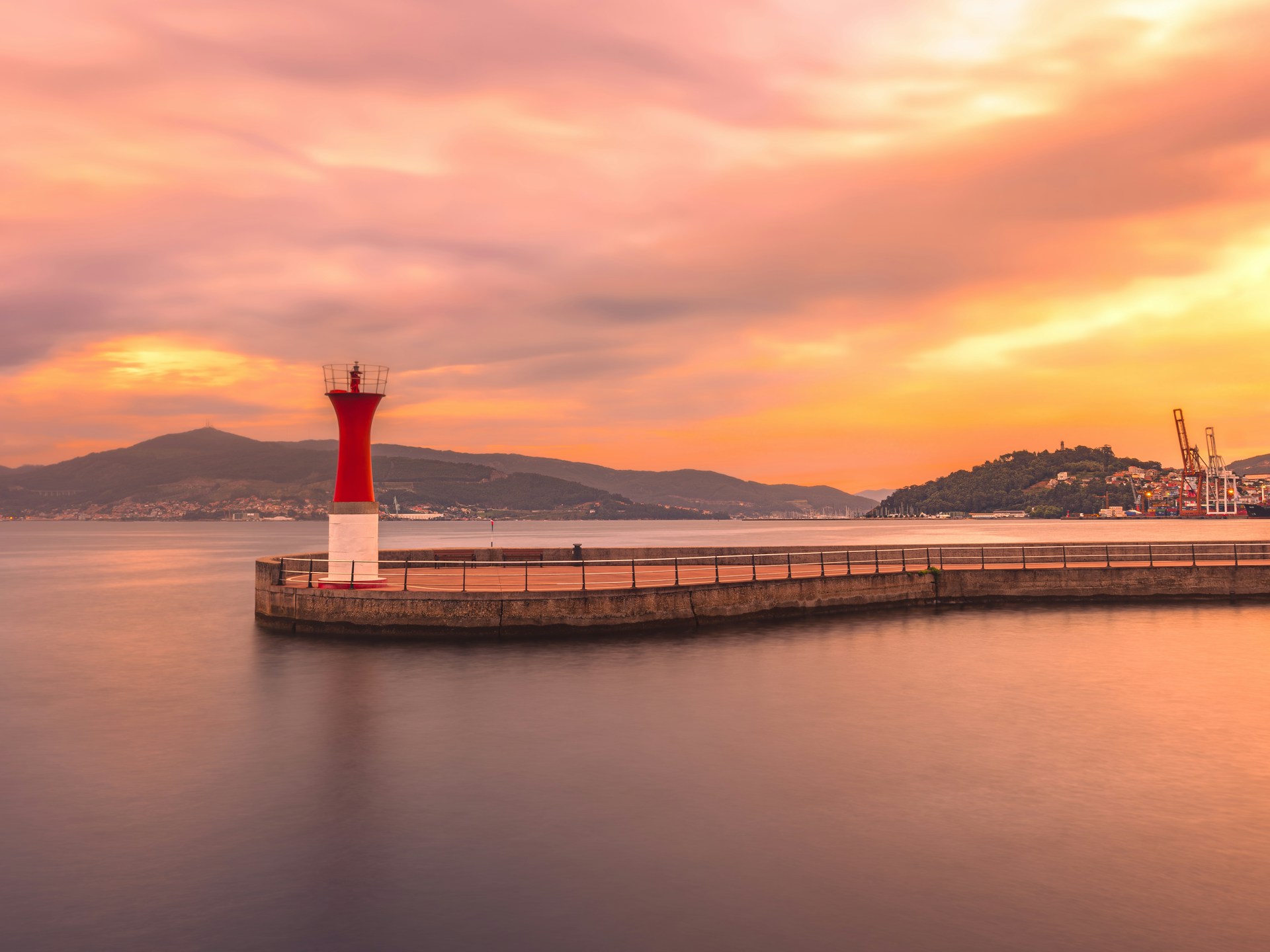 A red and white light house in the middle of a body of water
