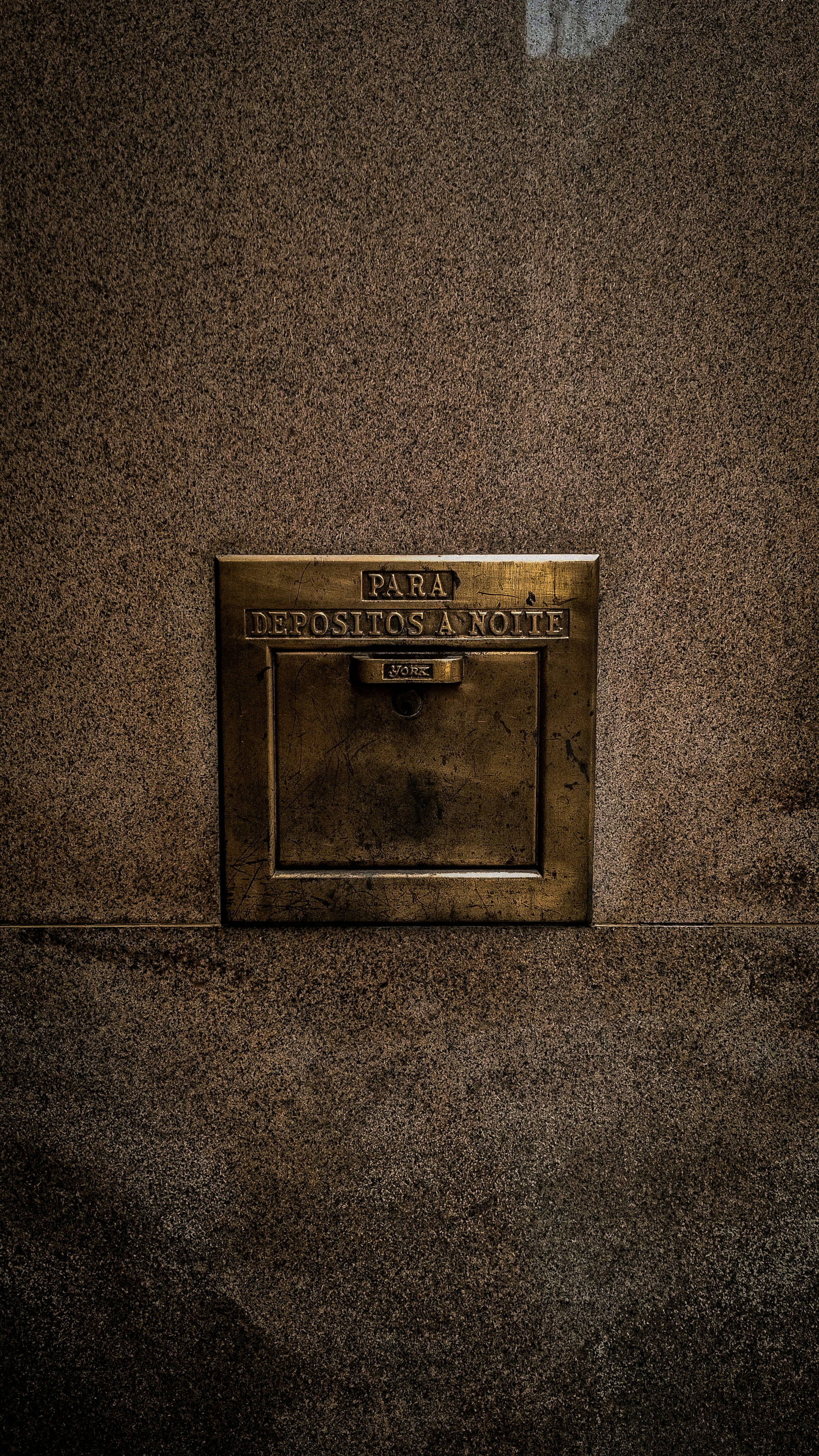 A wall mounted mailbox on the side of a building