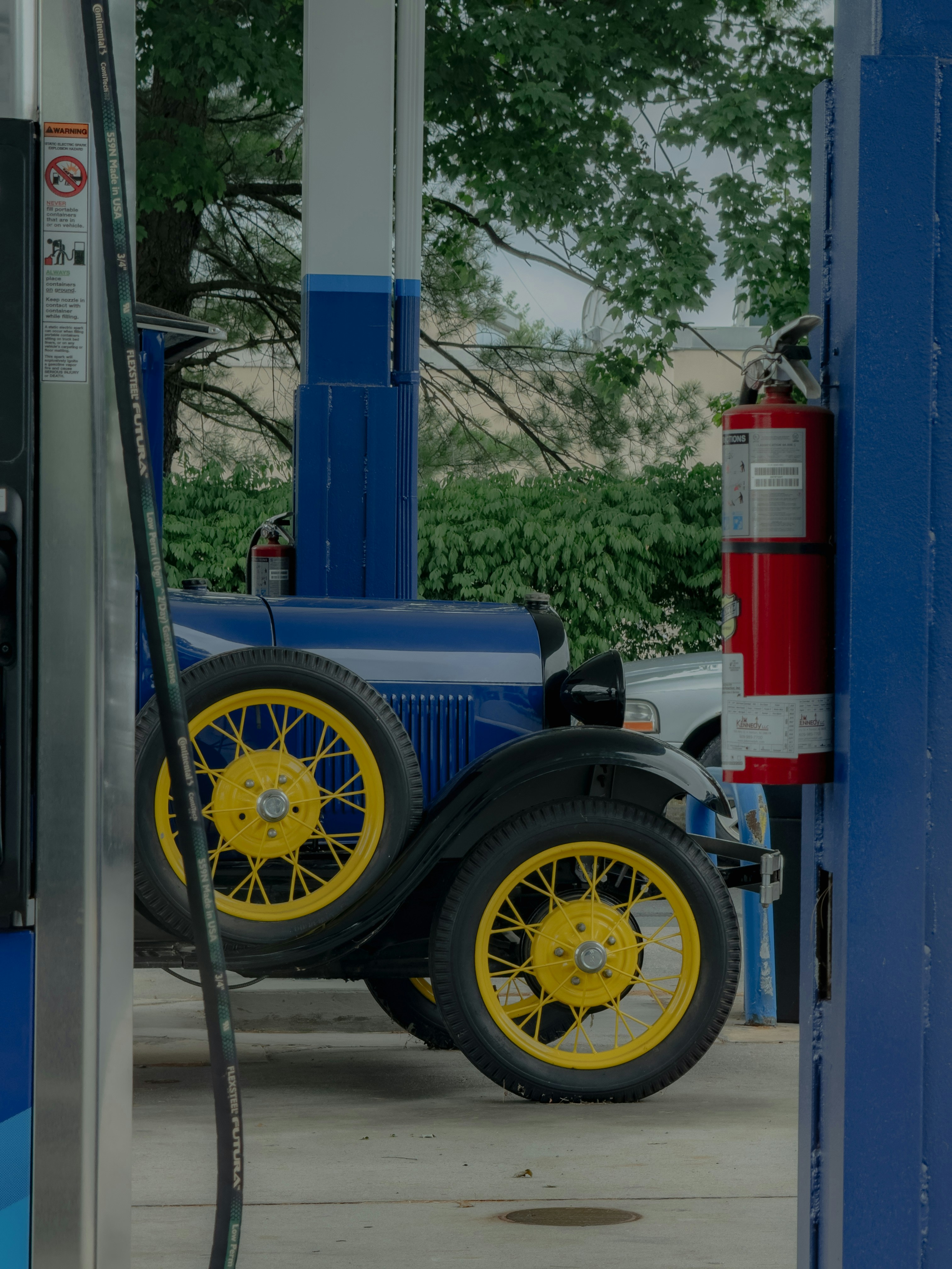 Pom bensin dengan mobil biru dan kuning
