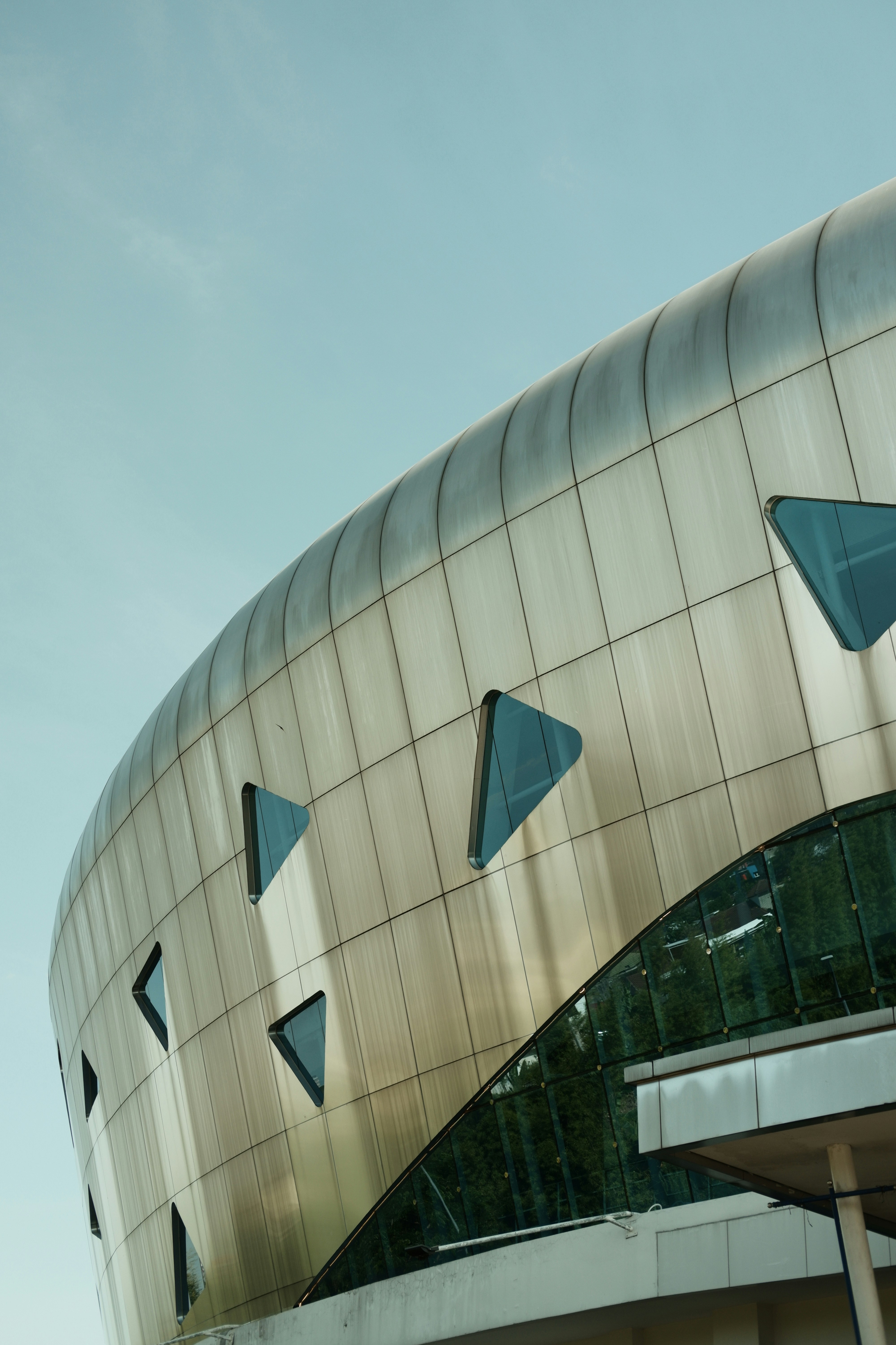 A large building with a curved roof and blue windows