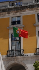 A flag flying in front of a building