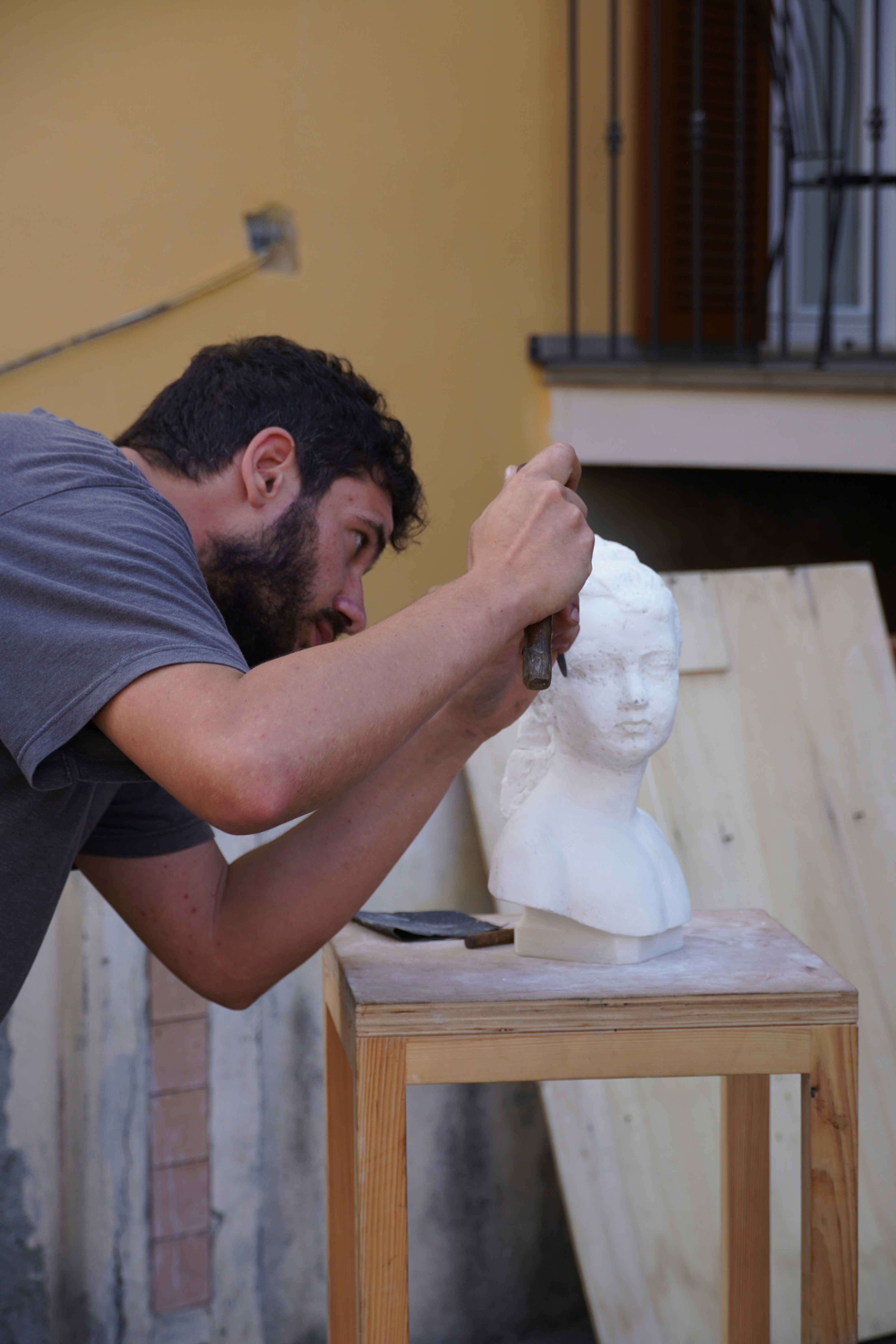 A man working on a statue of a head