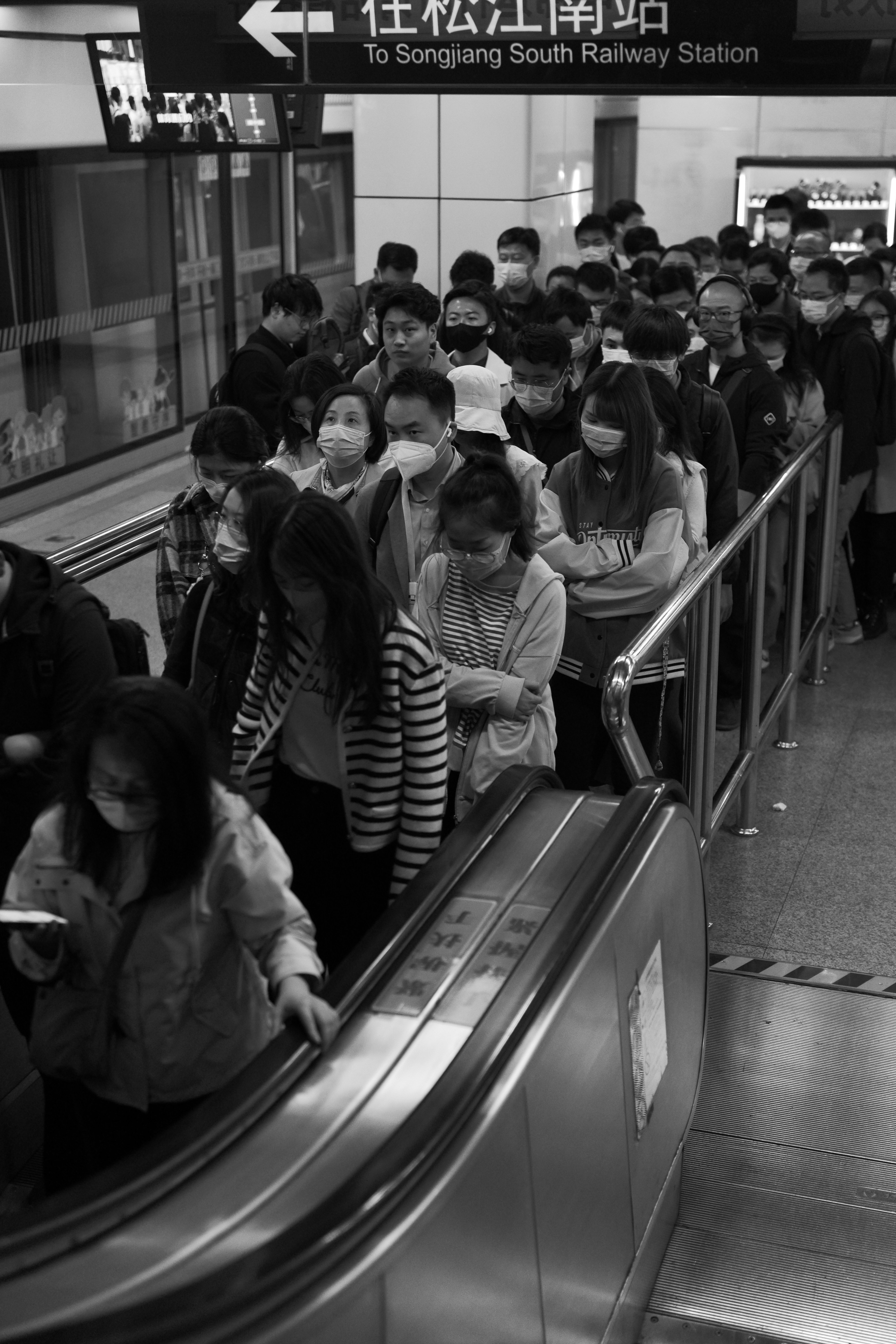 A group of people standing on an escalator