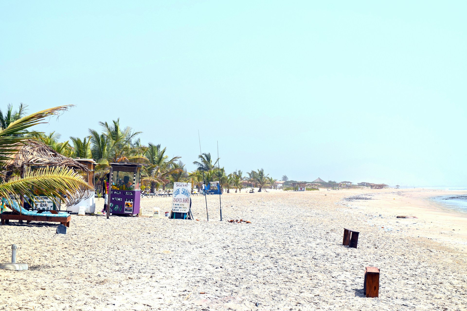 A sandy beach with a few chairs and umbrellas
