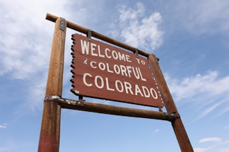 A welcome sign in front of a blue sky
