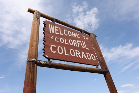 A welcome sign in front of a blue sky