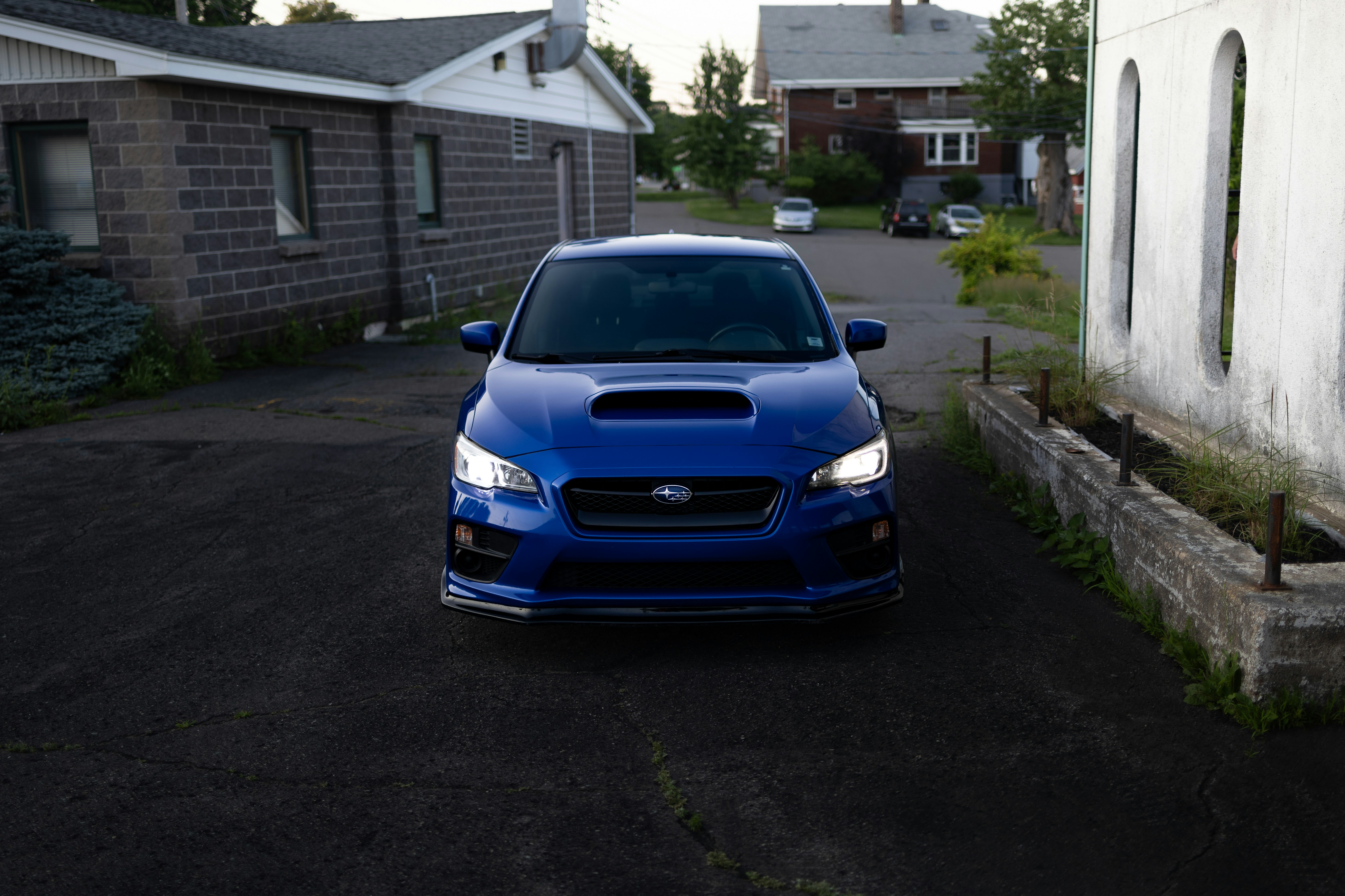 A blue subarunt parked in front of a house
